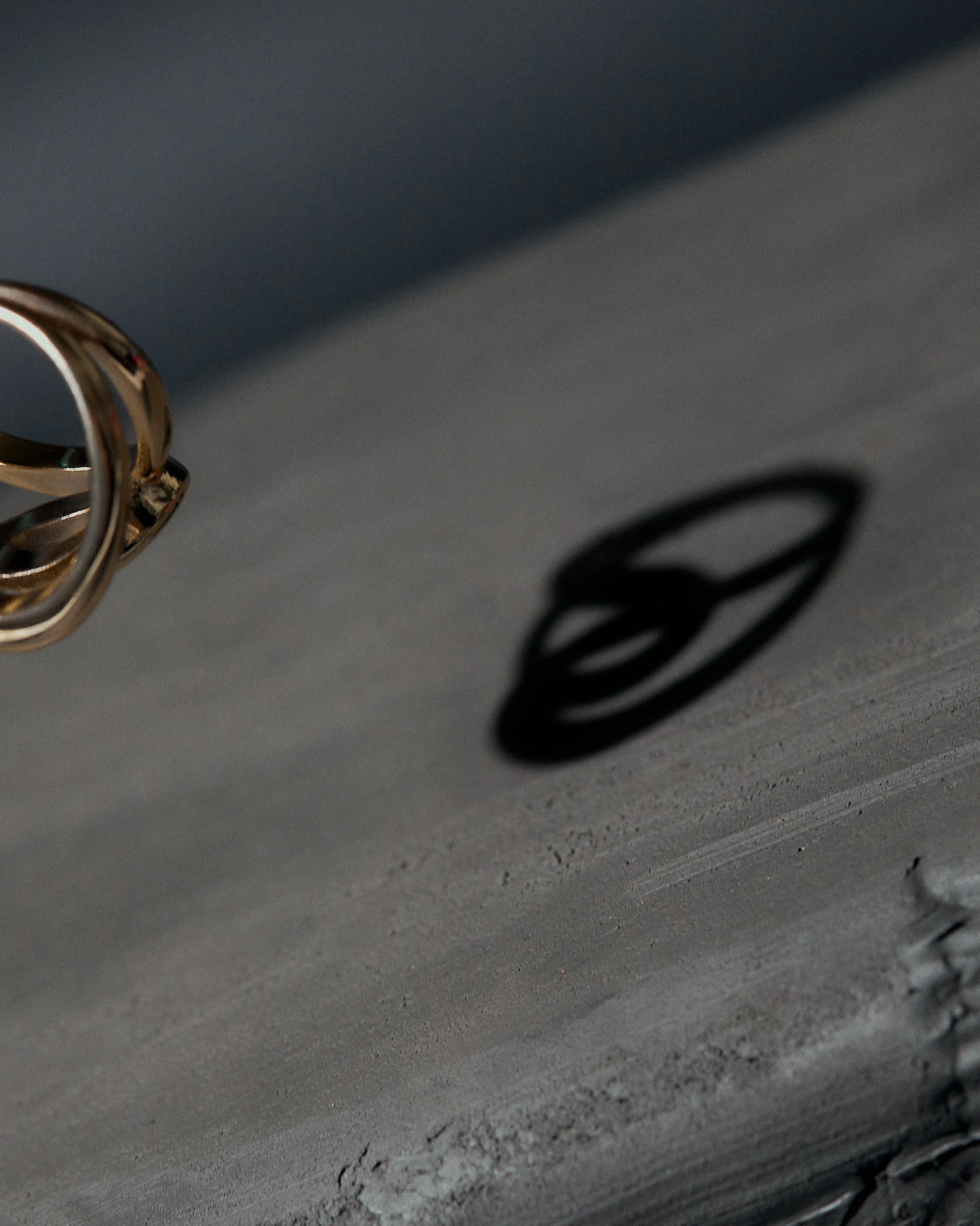 Close-up of a metallic lock with its shadow cast on a concrete surface.