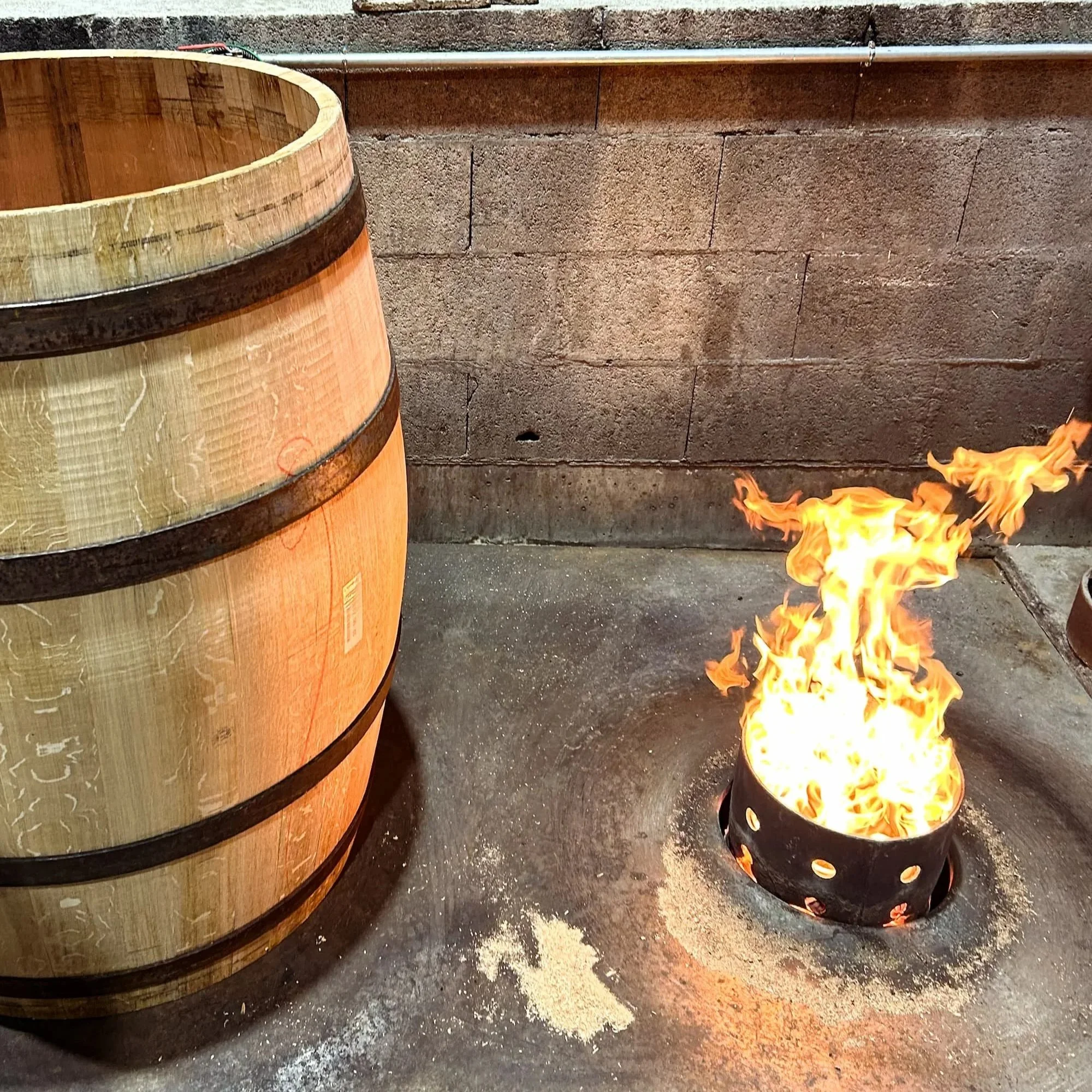 An Oak wine barrel sits over the brasier