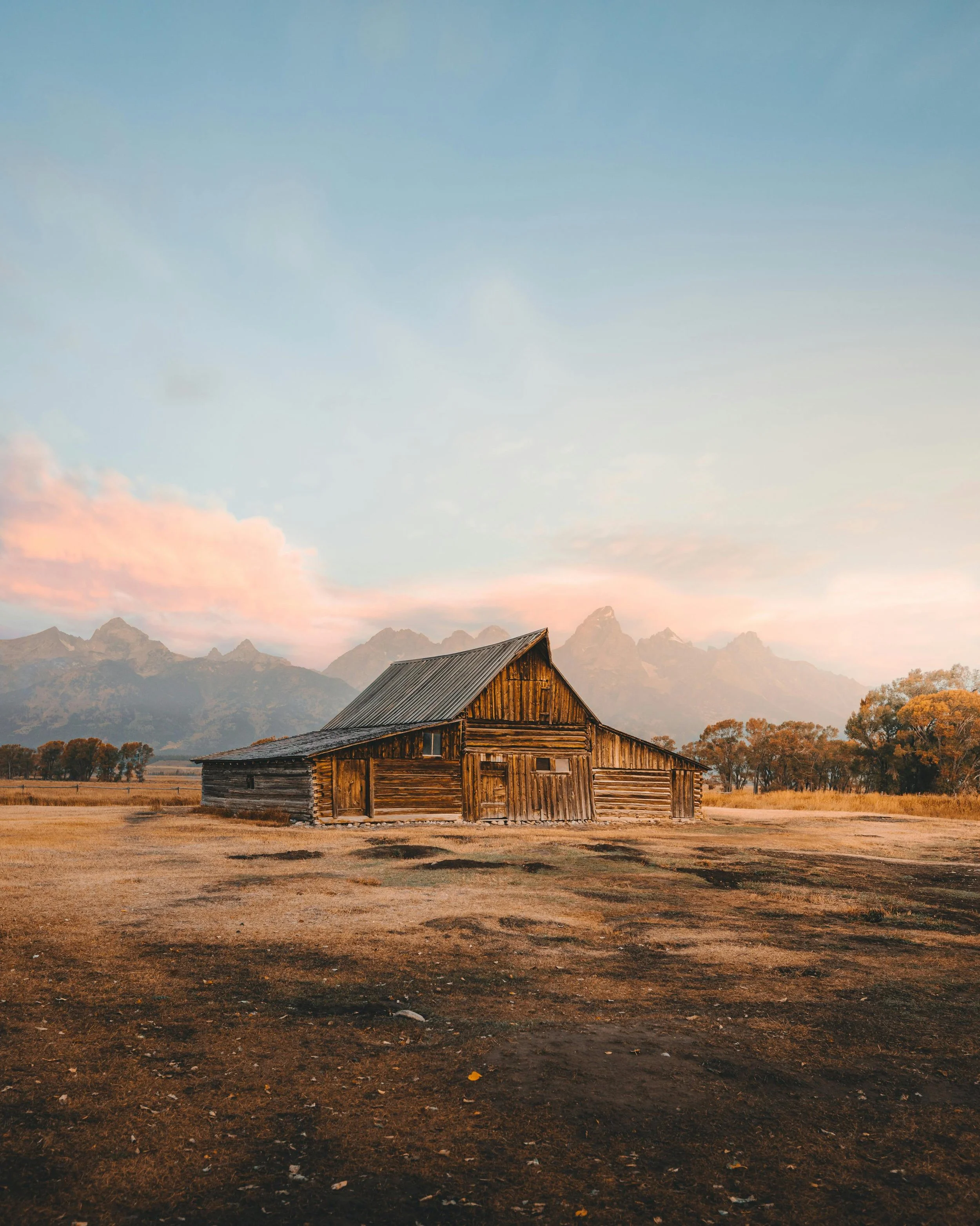 An old homesteading building in Grand Teton National Park at the forefront of the mountain range