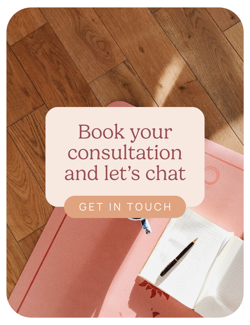 A pink yoga mat on a wooden floor with an open notebook, pen, and a water bottle on top, overlaid with text inviting to book a consultation and chat.