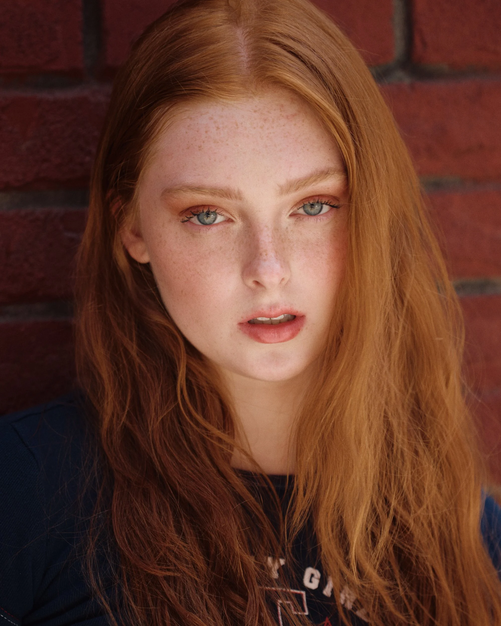 Red-haired woman against a brick wall, natural light beauty portrait | Jon Premosch, fashion and lifestyle photographer