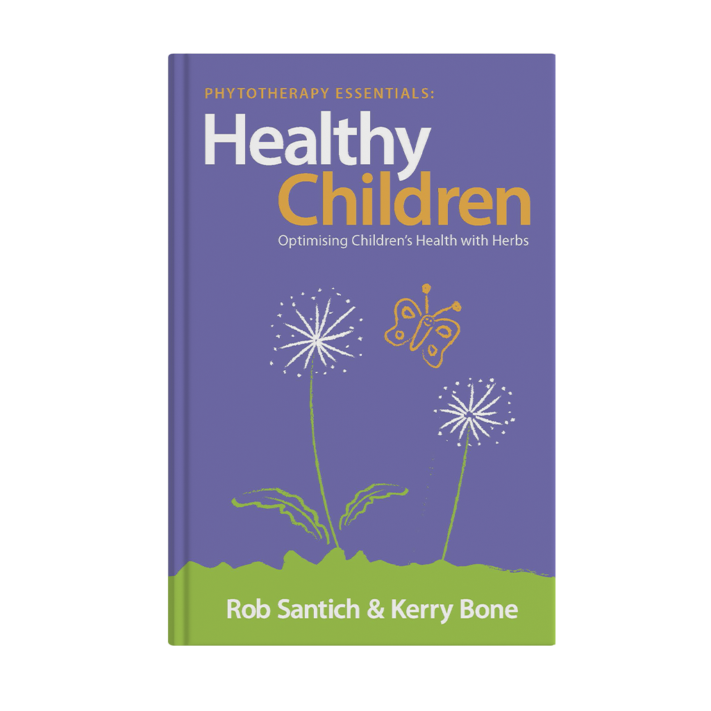 A book titled 'Healthy Children' with a purple cover, featuring white and yellow text and a simple illustration of dandelions and a butterfly in yellow and white on a green grass background.