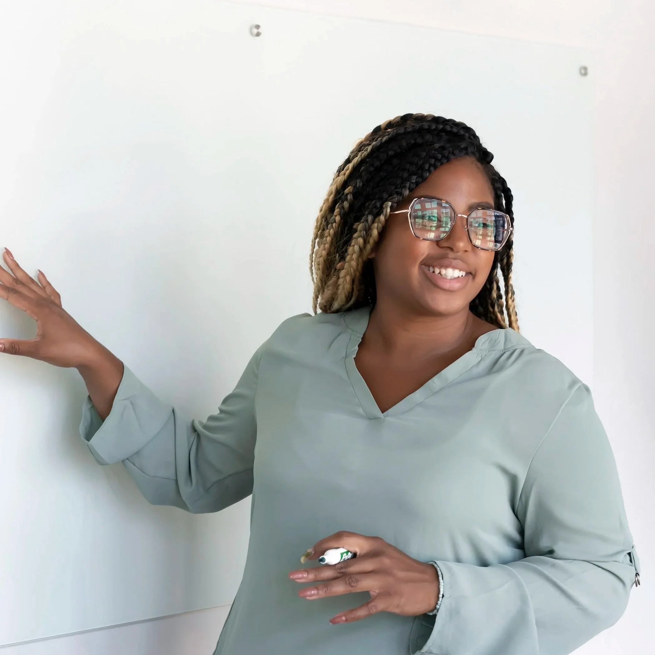 woman talking / presenting to peers while writing on presentation board