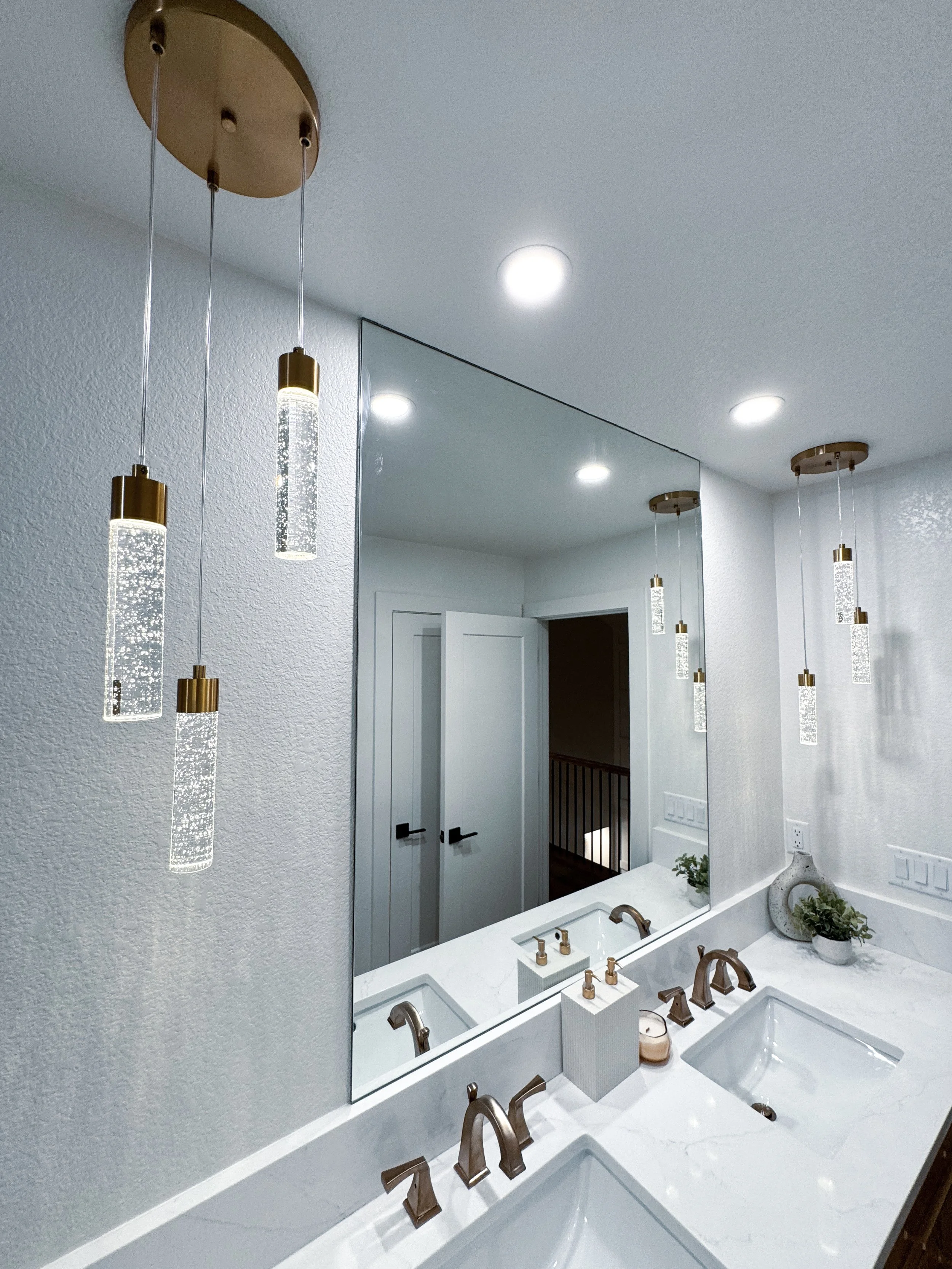 Fancy light fixture in a whole new bathroom in a house addition. Built by Stellaris Build Co.
