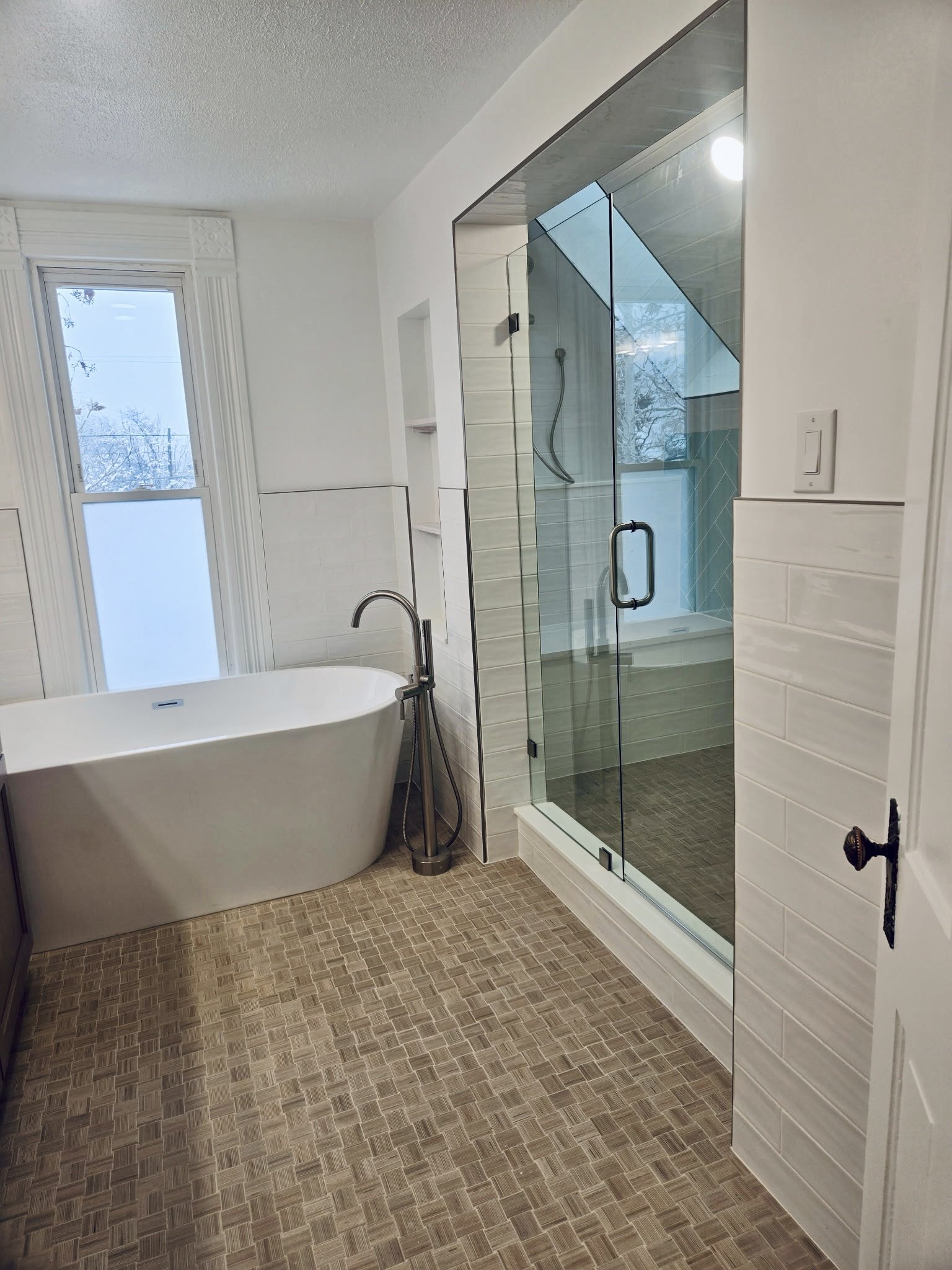 Colorado bathroom remodel with freestanding soaking tub, glass walk-in shower, and mosaic tile flooring