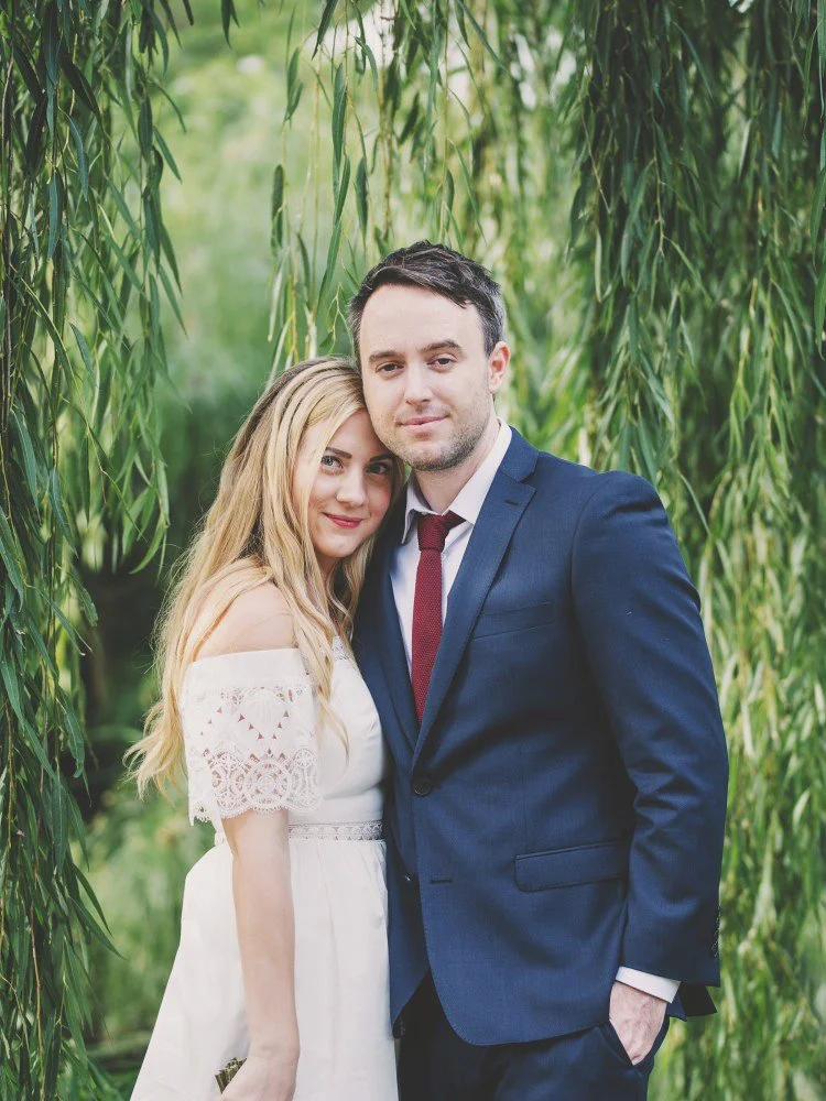 Bride and groom standing beneath a willow tree in the Adelaide Botanic Gardens