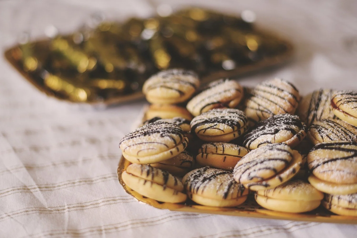 A tray of sugar coated biscuits drizzled with chocolate