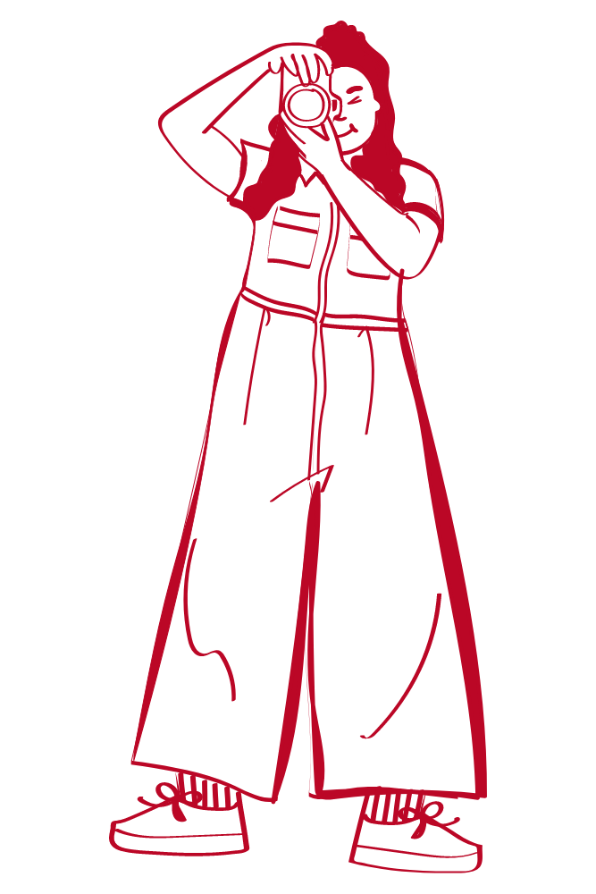Outline drawing of a person wearing a jacket, wide-leg pants, and sneakers, with long hair and holding a camera up to their face.
