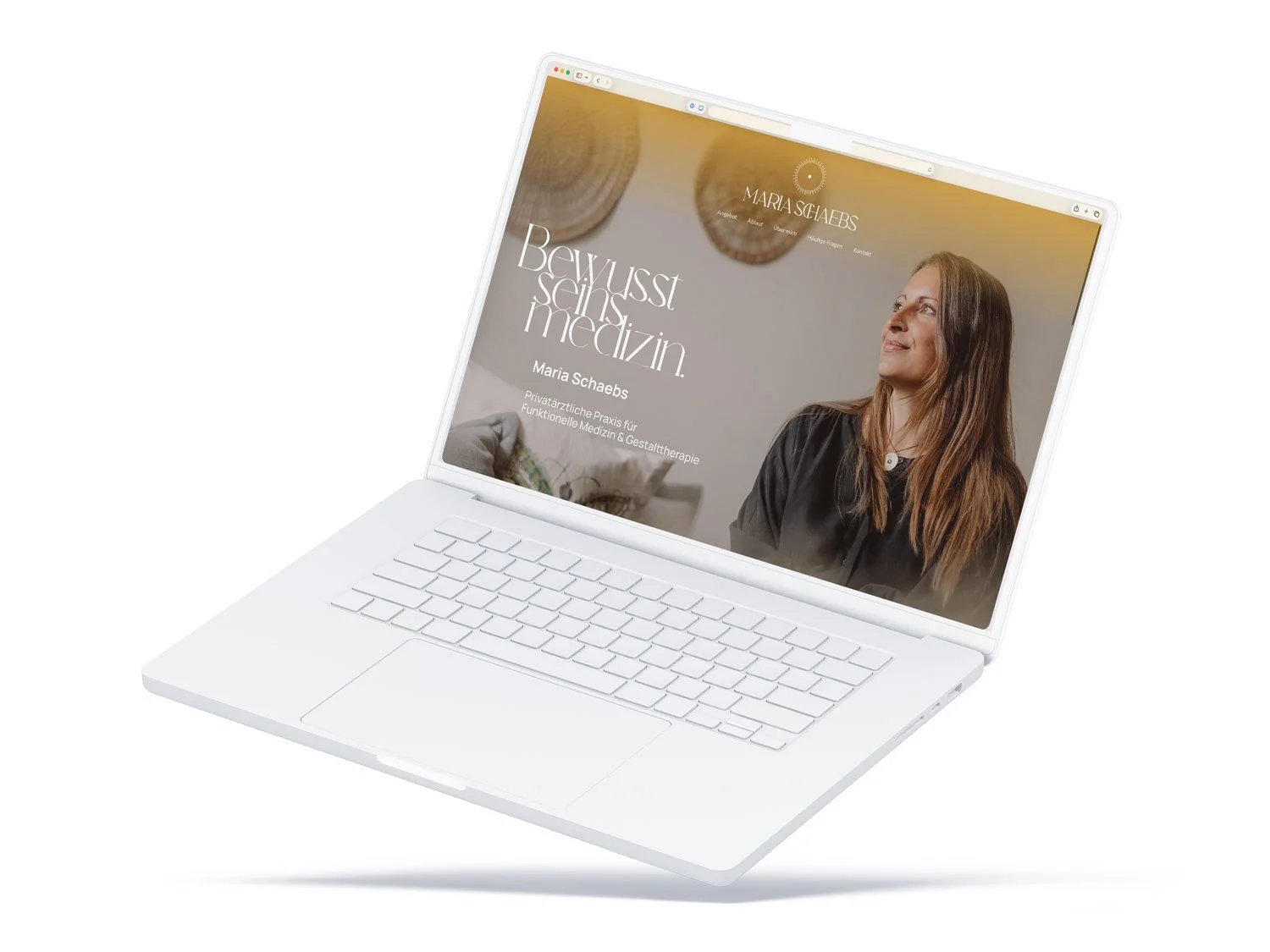 Startseite der Website maria-schaebs.de auf einem weißen Laptop mit dem Slogan „Bewusstseinsmedizin“, Porträtfoto von Maria Schaebs und Praxisbezeichnung für Funktionelle Medizin & Gestalttherapie.