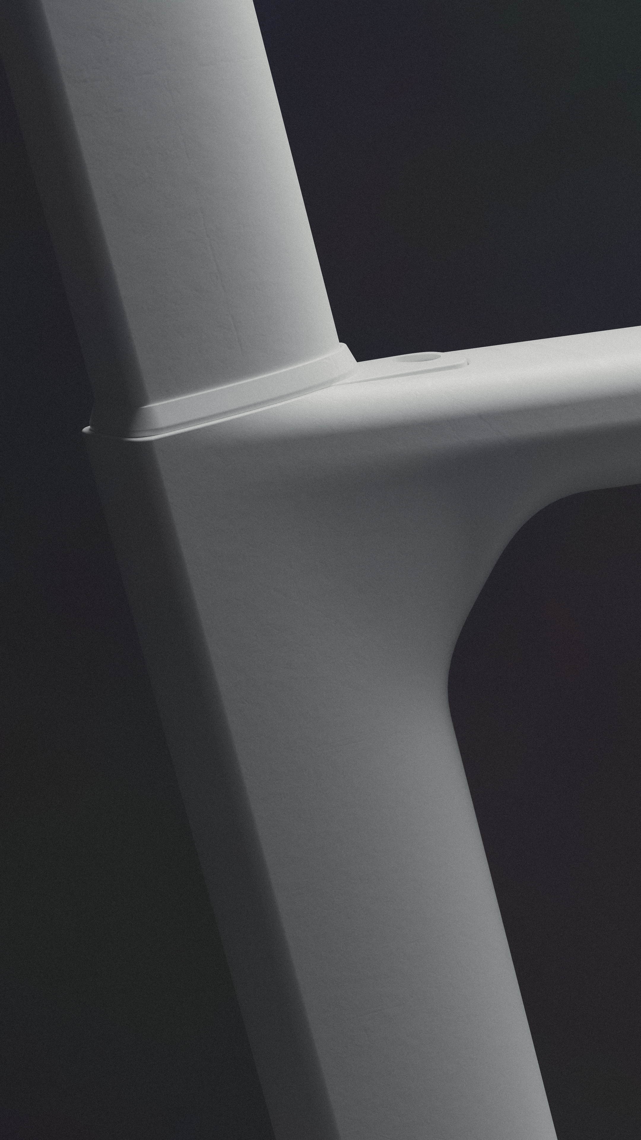 Close-up of a seat tube area of a road bike with white surface, against a dark background, with partial shadow.