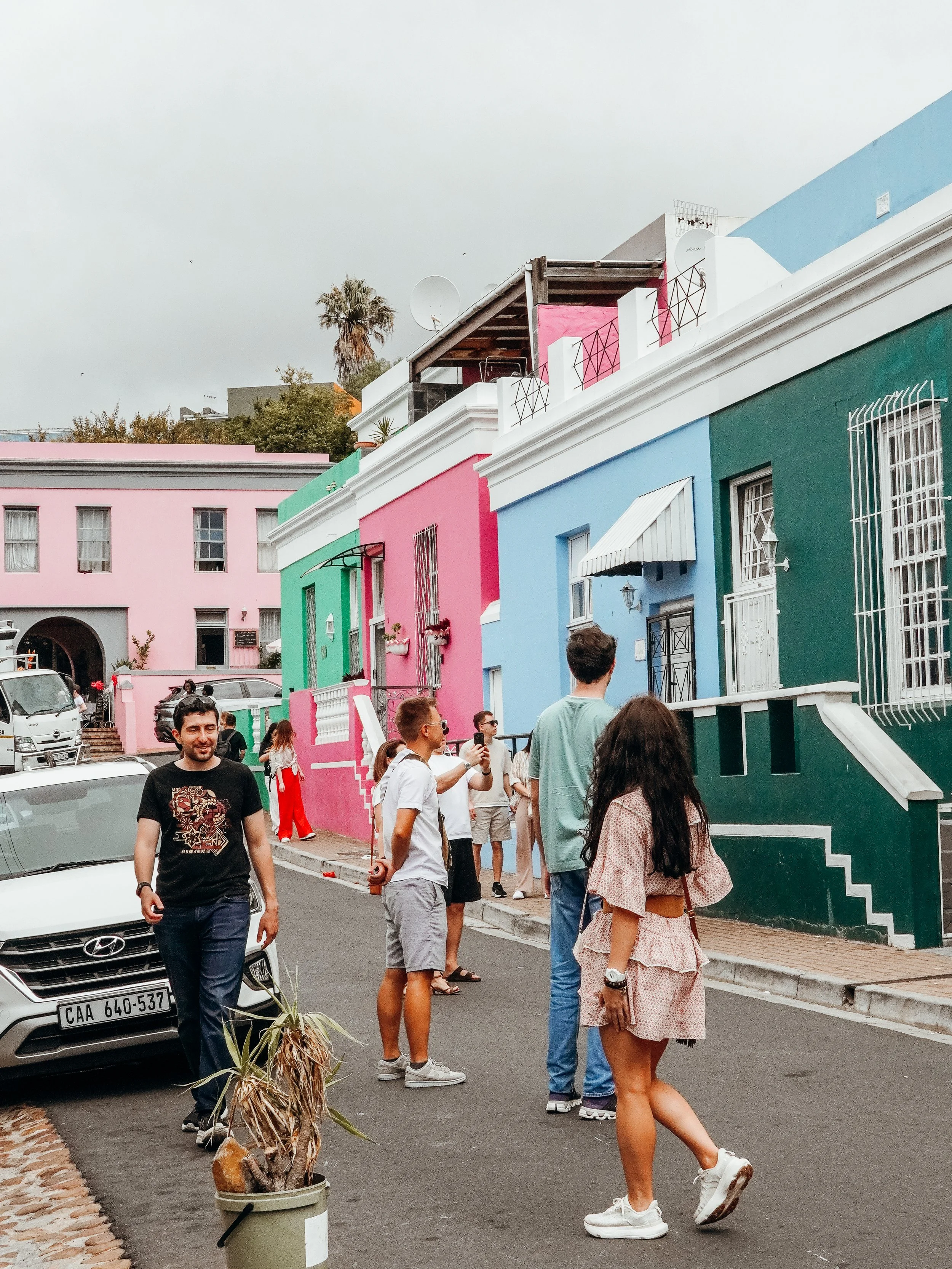 Tourists exploring the colorful Bo-Kaap streets in Cape Town with vibrant historic houses.