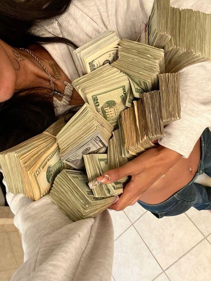 Person holding large stacks of US dollar bills.