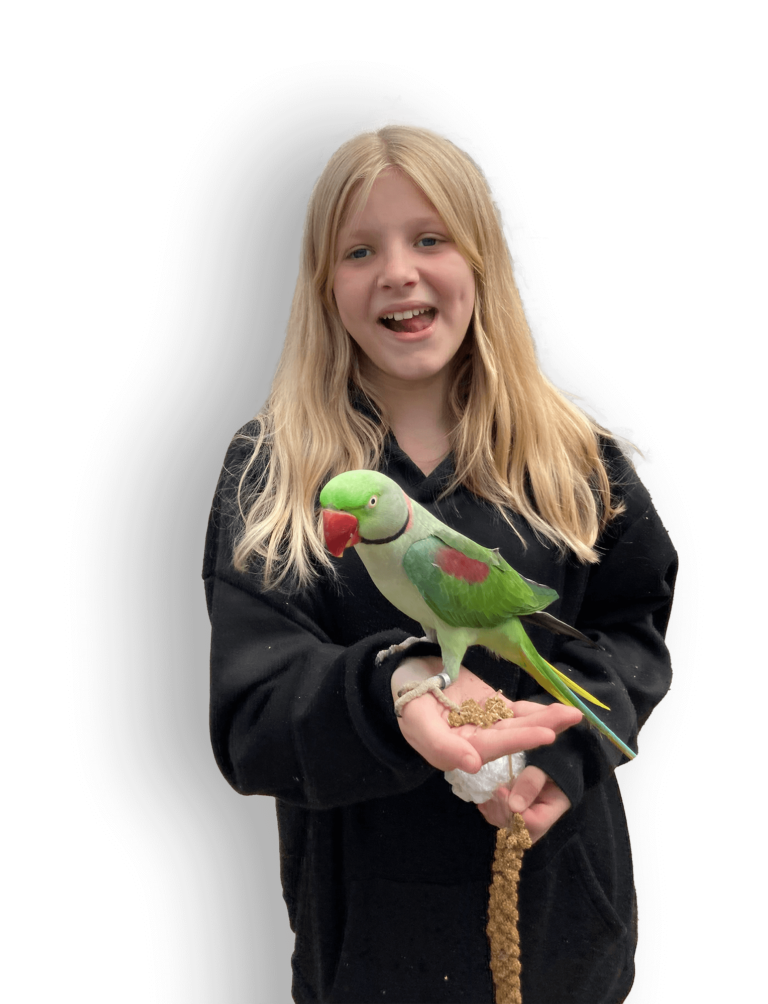 A young girl with blonde hair wearing a black hoodie, smiling and holding a colorful parrot on her hand, against a black background.