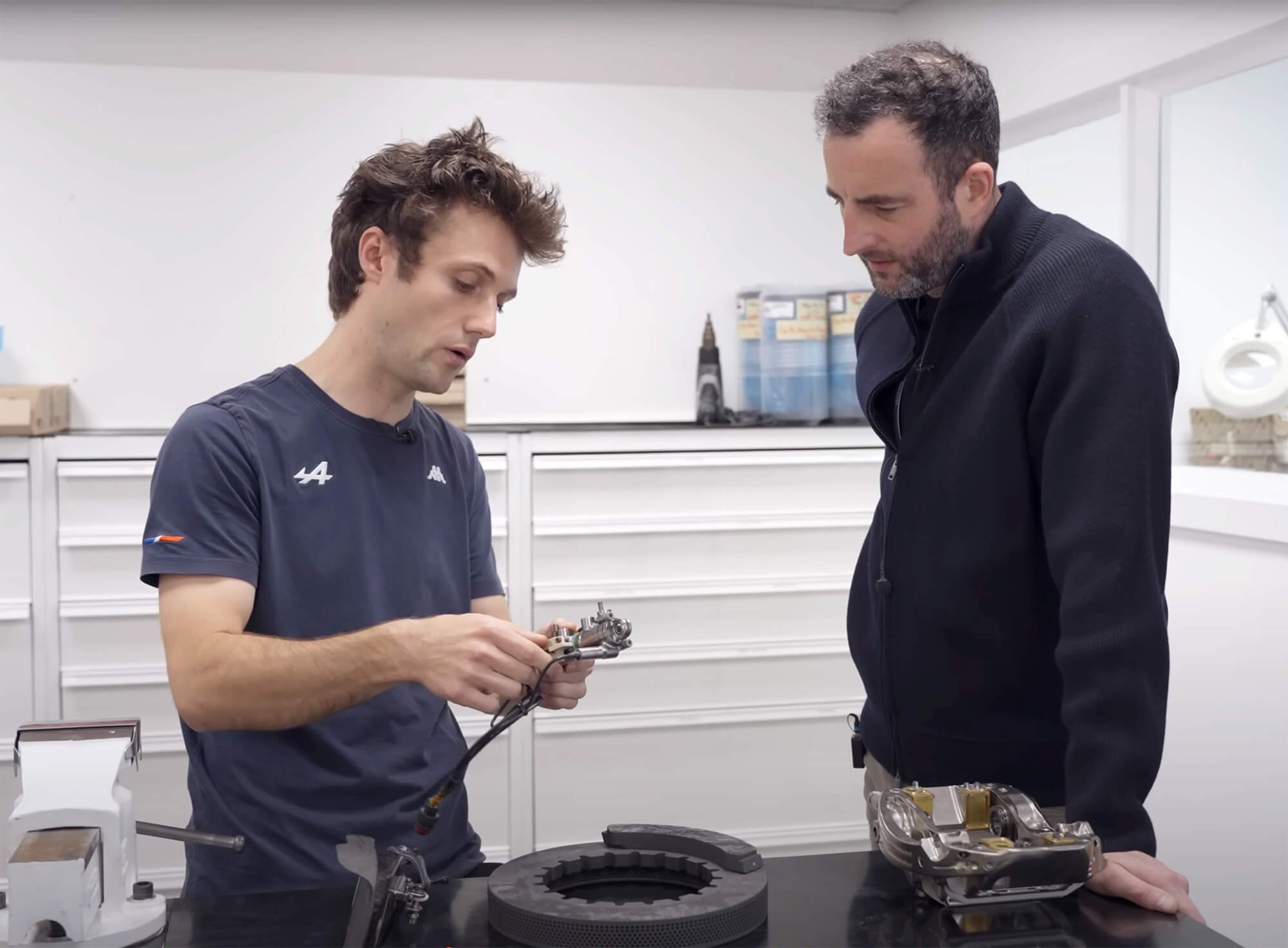 Two men in a workshop examining a mechanical component.