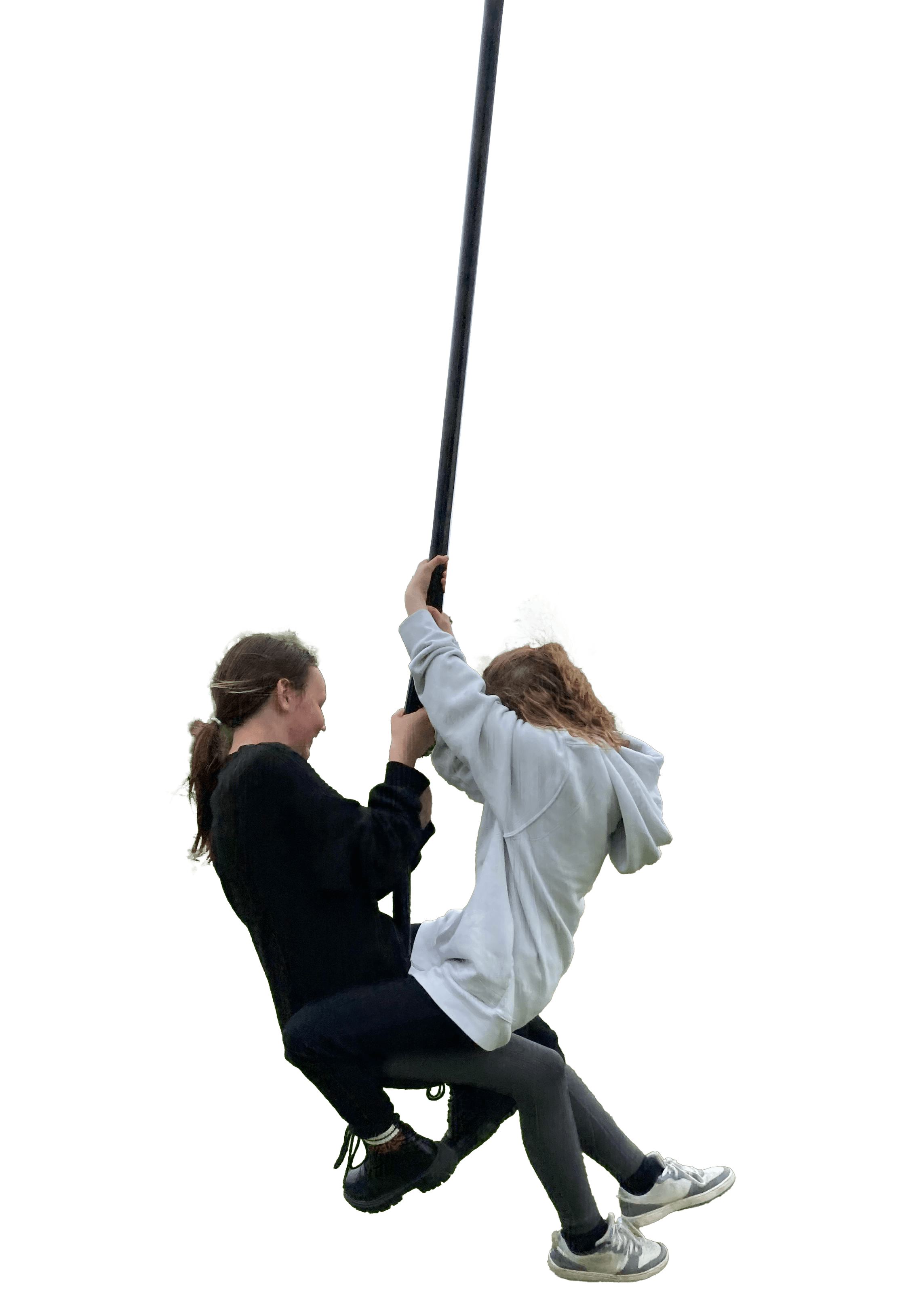 Two young women are climbing on a rope, with one holding the rope and the other sitting on a platform, against a black background.