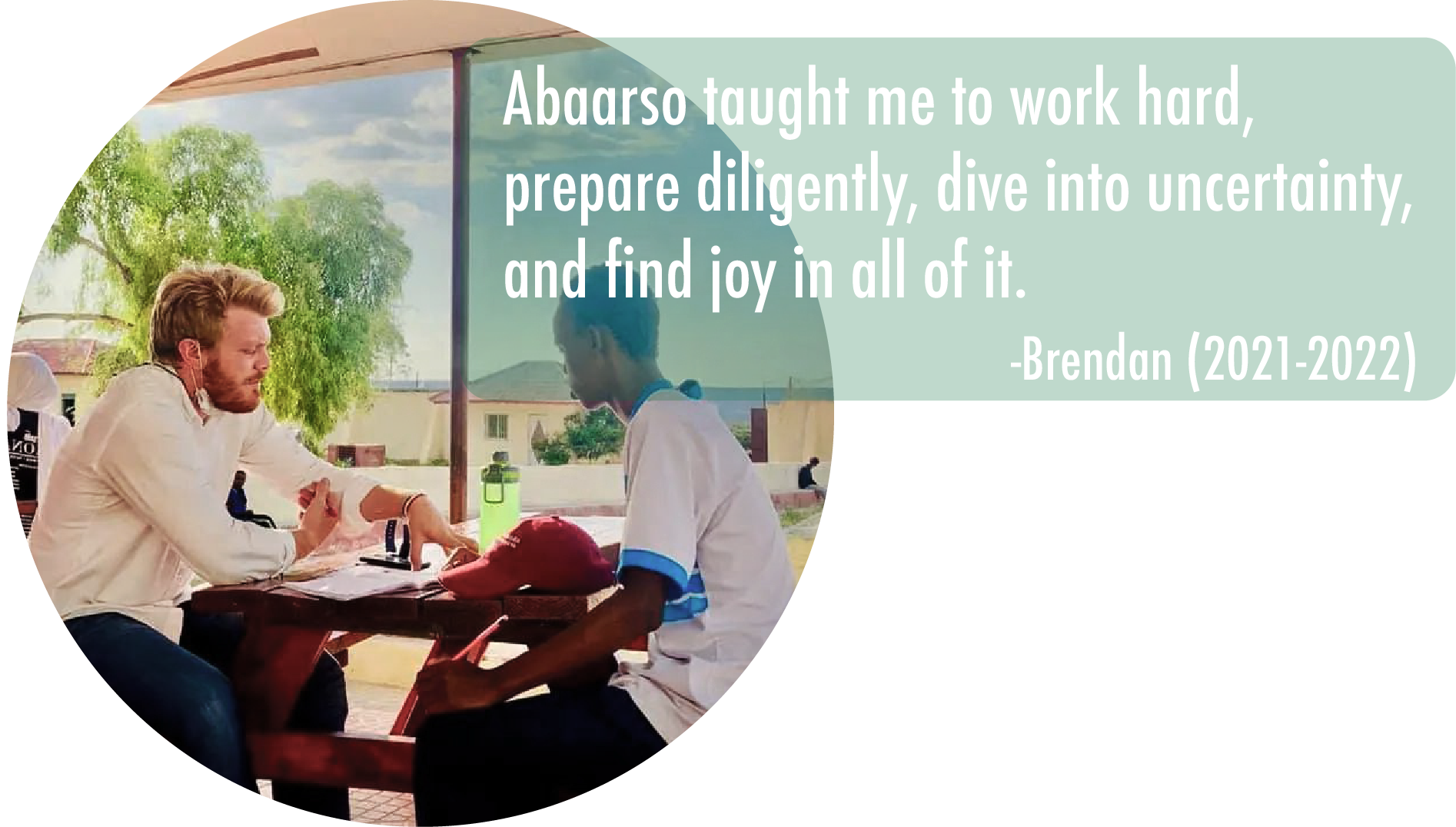 A man and a boy sitting at a table outdoors, engaged in conversation. The scene is sunny with trees and buildings in the background. Overlaid on the image is a quote by Brendan reading, 'Aabaro taught me to work hard, prepare diligently, dive into uncertainty, and find joy in all of it. -Brendan (2021-2022).'