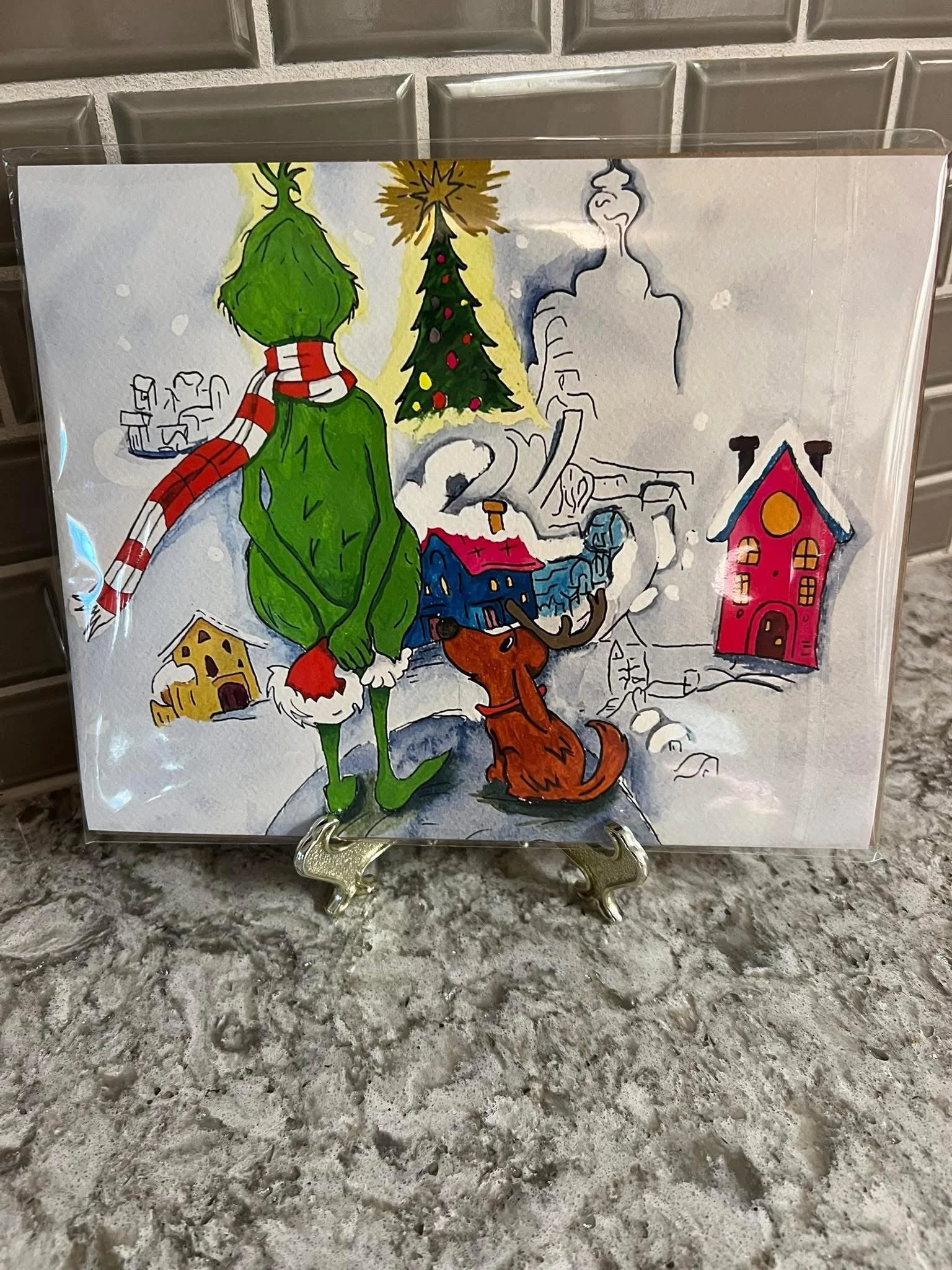 Colorful Christmas illustration with a tall green Grinch, Santa hat, and red-and-white-striped scarf, standing next to a happy brown dog. Snowy background with decorated Christmas trees, colorful houses, and smoke coming from smokestacks.