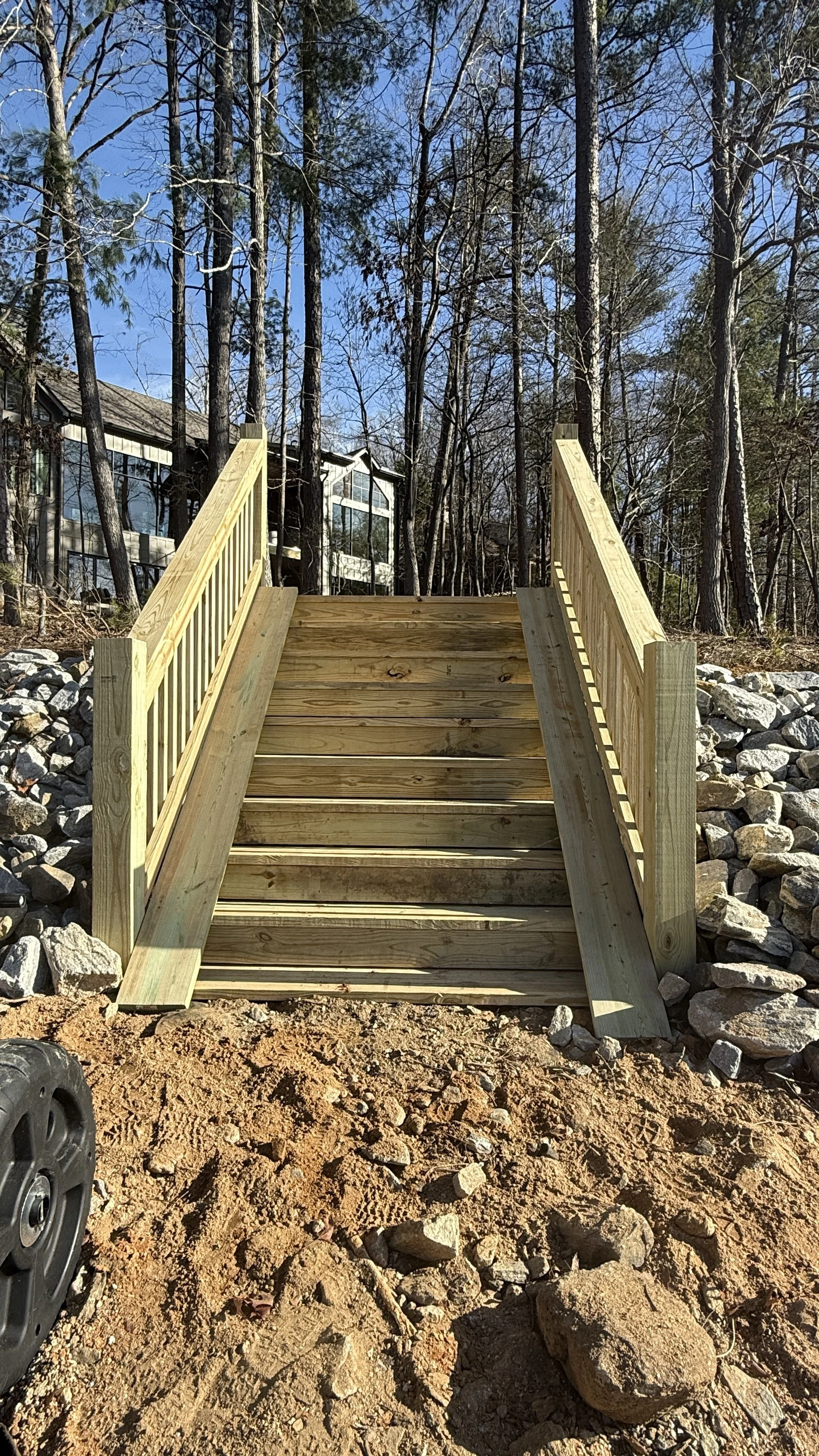 Custom pressure treated wood staircase with railings and riprap built by Lawn Warriors on a North Georgia lake property