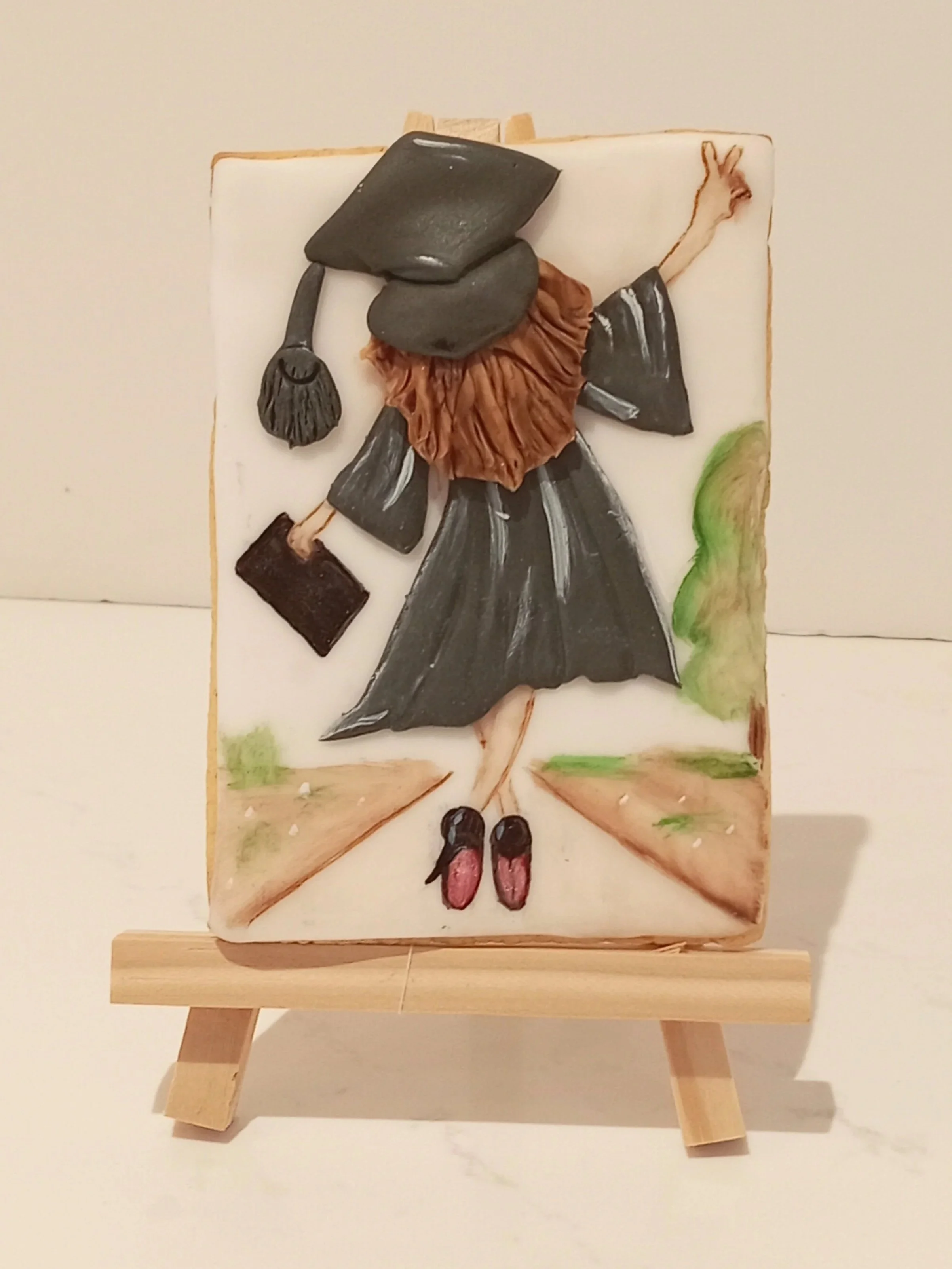 Decorative art featuring a woman in a black dress and hat, holding a purse, with a painted outdoor background.