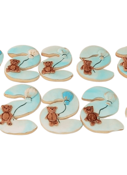Decorative cookies shaped like numbers 2024 with teddy bear and stethoscope designs, decorated in light blue, brown, and white icing.