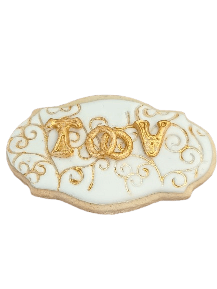 Decorated sugar cookie with white icing, gold swirl patterns, and golden letters spelling 'LOVE' with intertwined rings.