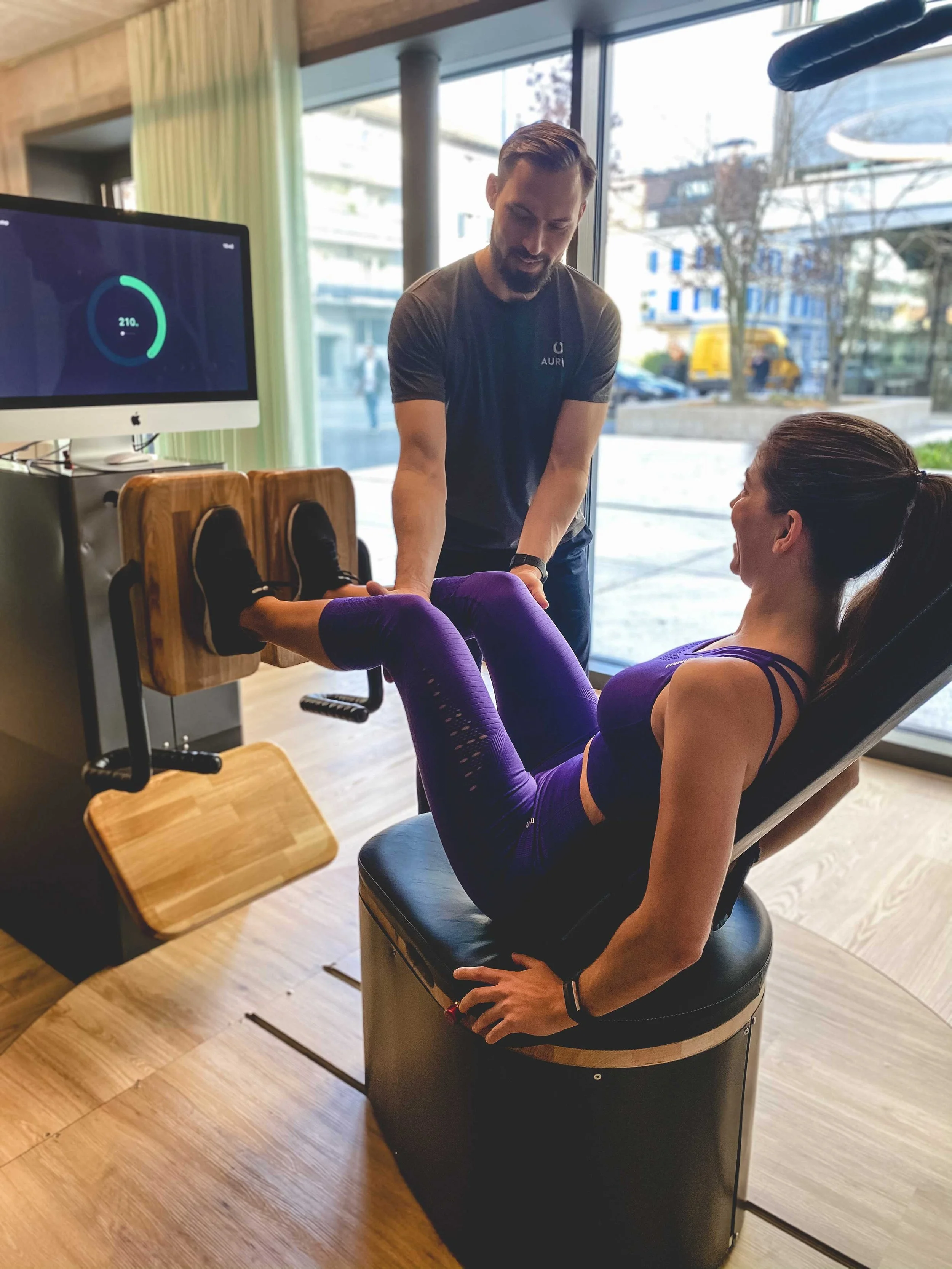 Ein Trainer unterstützt die Trainierende bei der Legpress