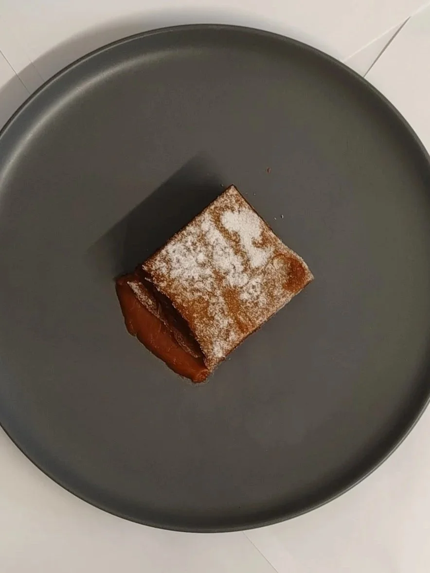 Sticky toffee pudding dusted in icing sugar