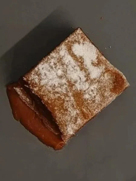 Sticky toffee pudding dusted in icing sugar