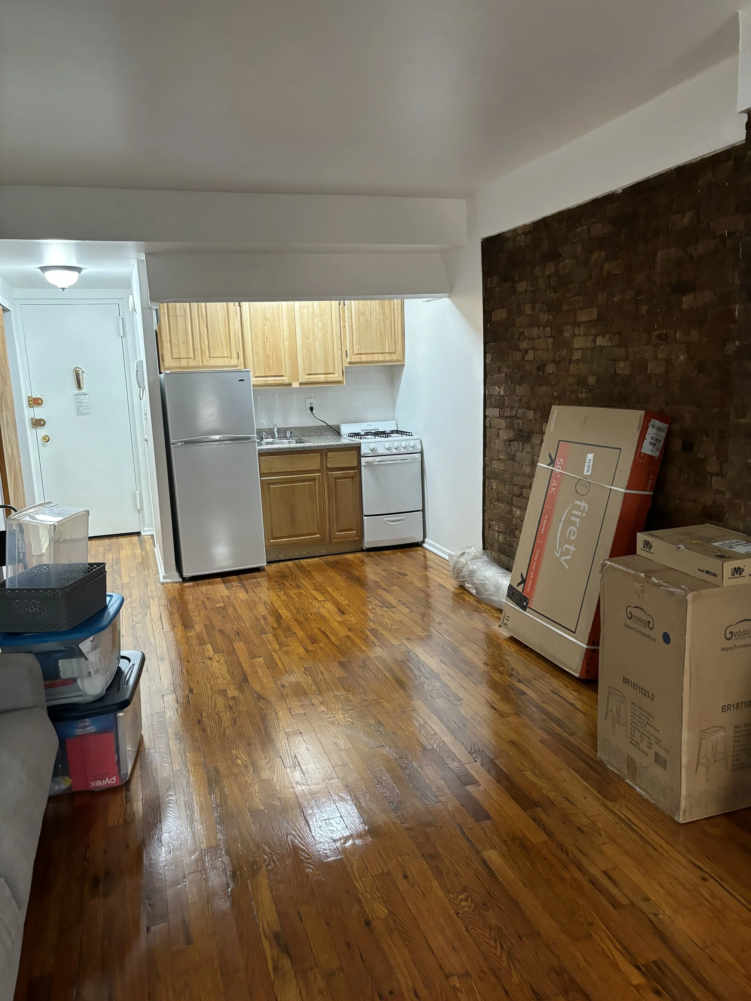Empty NYC studio apartment before move-in day, hardwood floors and open layout ready to be organized