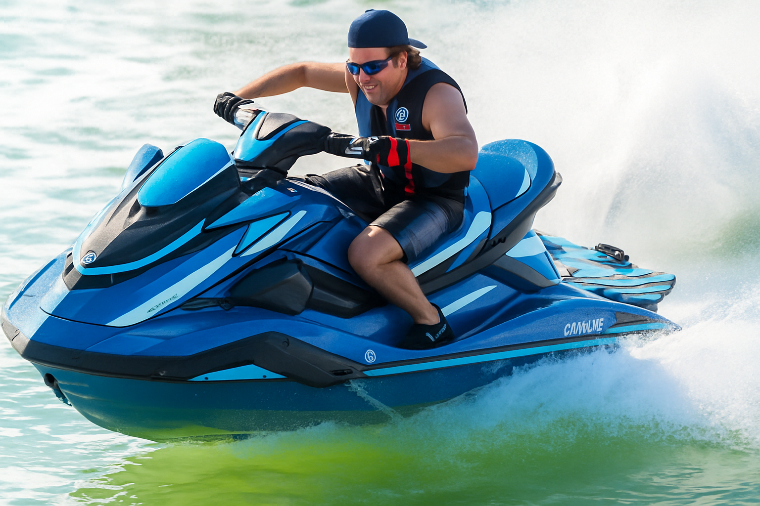 A man in sunglasses and a life vest riding a blue Yamaha jet ski on the water with a spray of water behind him.