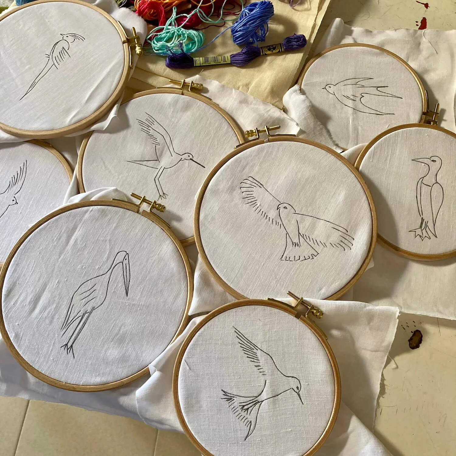 Echantillons de broderie avec des dessins d'oiseaux en cours de réalisation.