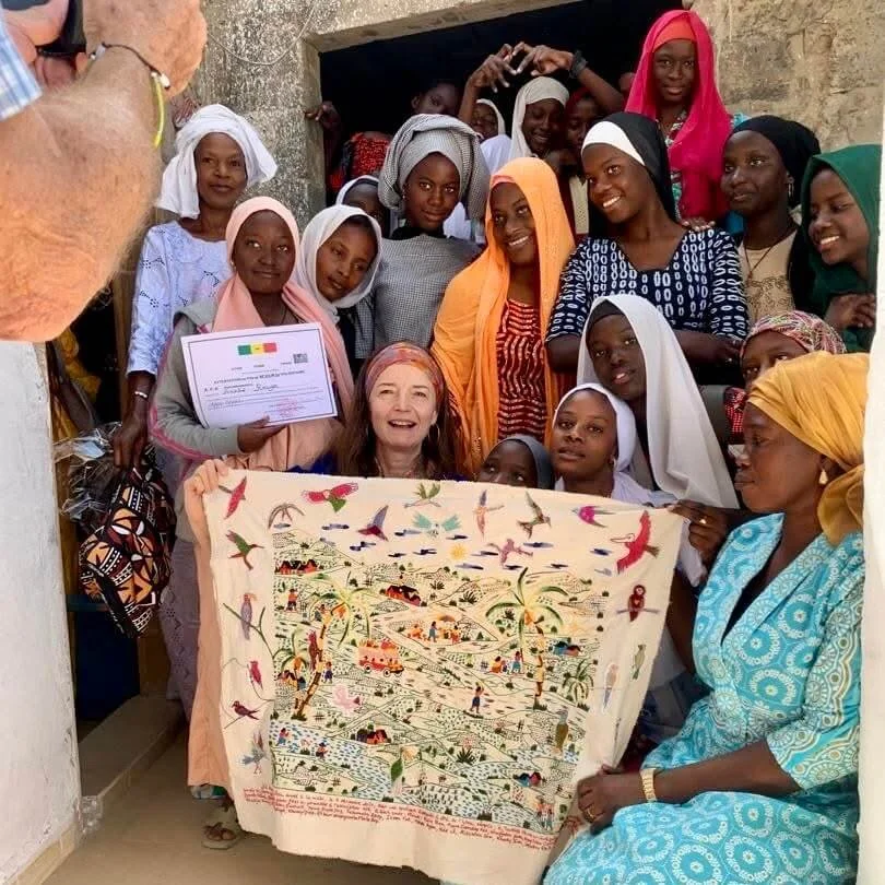 Amélie Rouyer, les jeunes filles de l'association Action Femme Enfant à Saint-Louis-du-Sénagal, leur enseignante Marie Diop, la directrice Yacine Ba fêtent la réalisation de 'La conférence des oiseaux'.