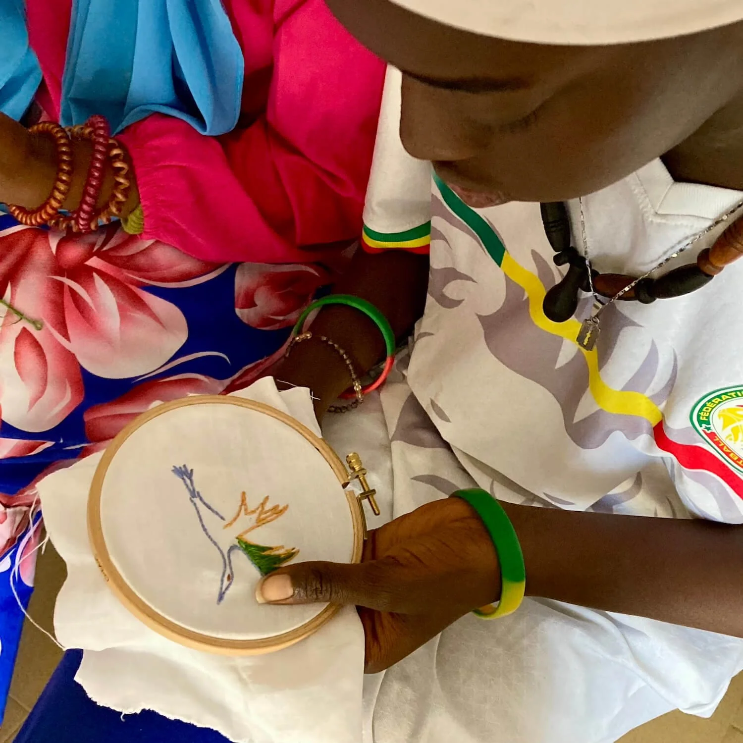 Une jeune fille de l'association Action Femme Enfant à Saint-Louis-du-Sénégal brode un oiseau pour la pièce collective 'La conférence des oiseaux'.
