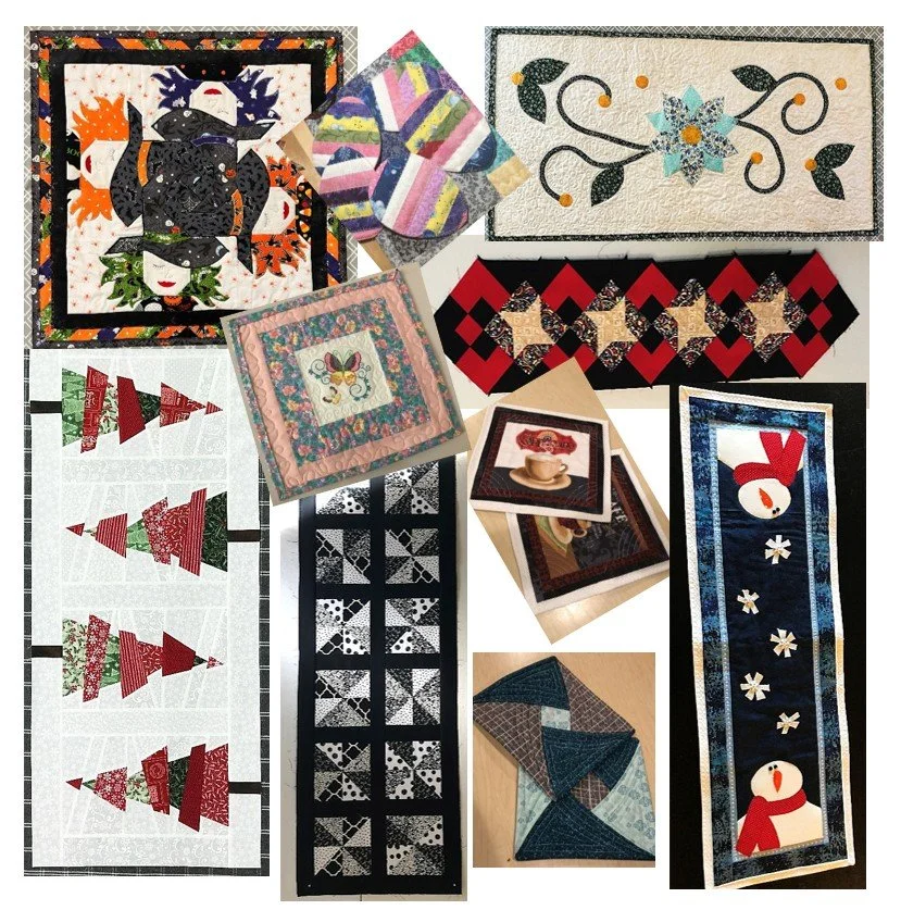 A collection of Christmas-themed quilted items, including square wall hangings, table runners, and folded quilt blocks with designs like snowmen, Christmas trees, and festive patterns.