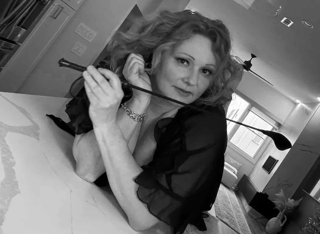 Maayan Noir reclining in an intimate setting, private tantric sessions for men focused on masculine vitality and embodied presence.