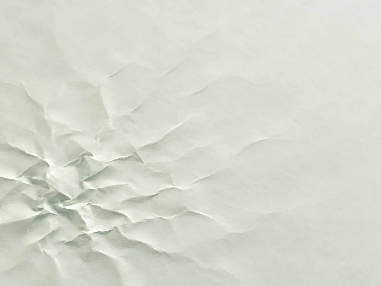 Fine creases cluster toward the lower left of a pale green-white surface and fade into open space at the upper right.
