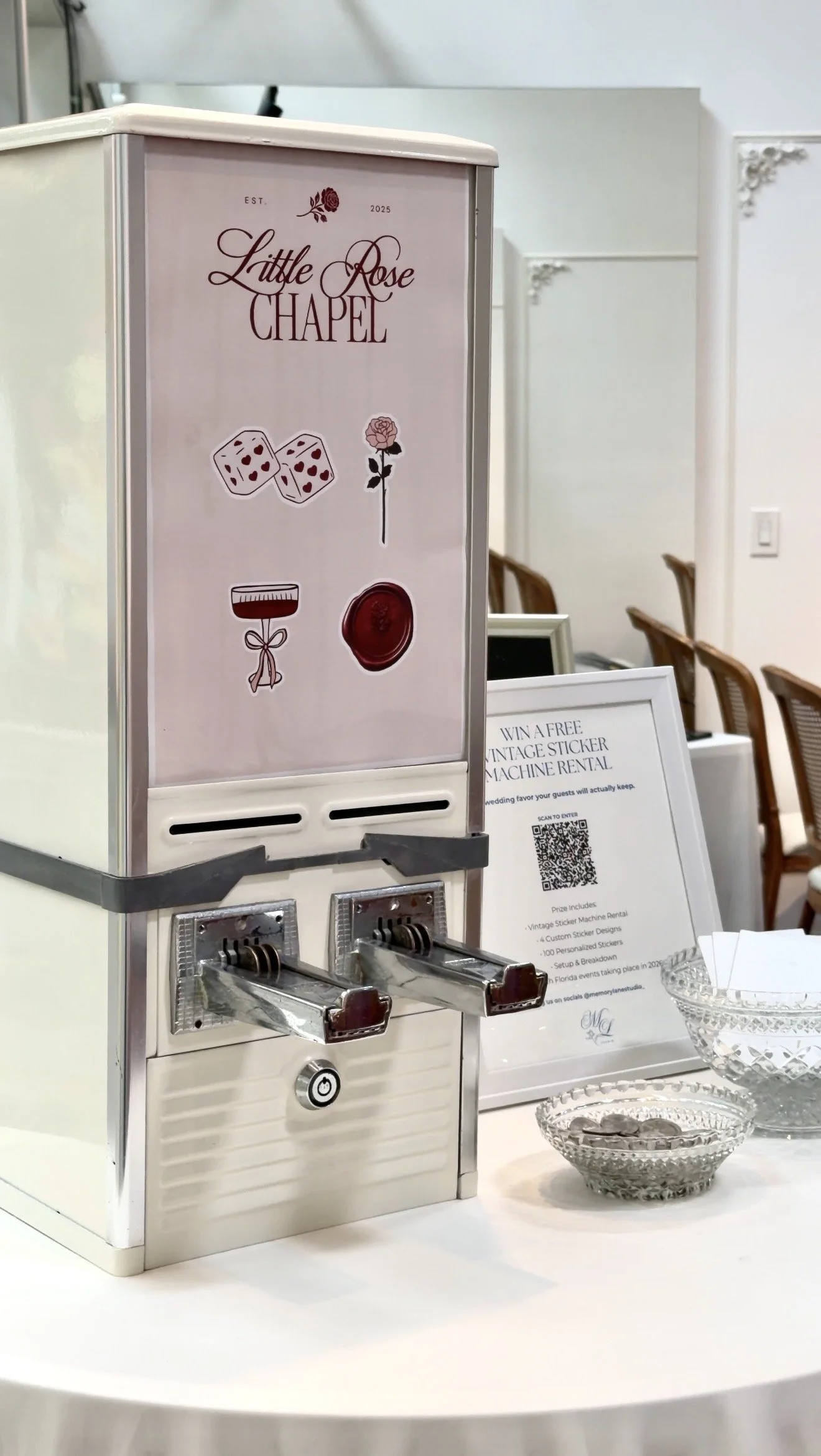 A vintage sticker machine rental at an event, featuring a sign for Little Rose Chapel.