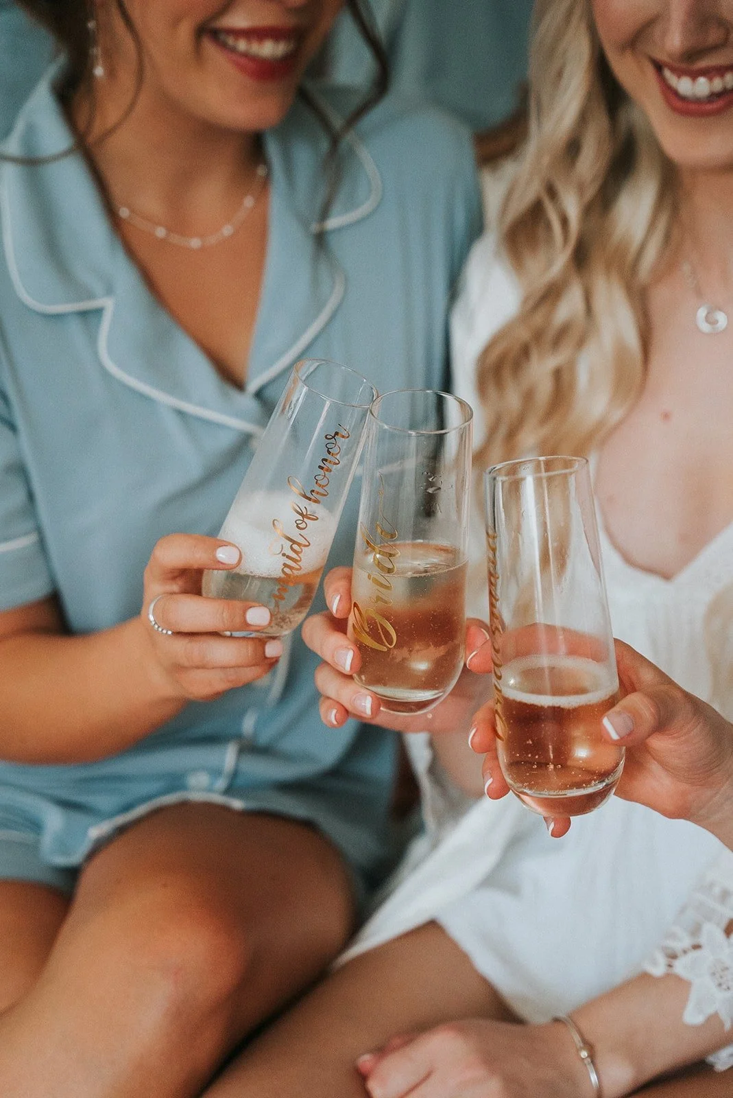 Three women in pajamas toasting with glasses of champagne, celebrating a special occasion.