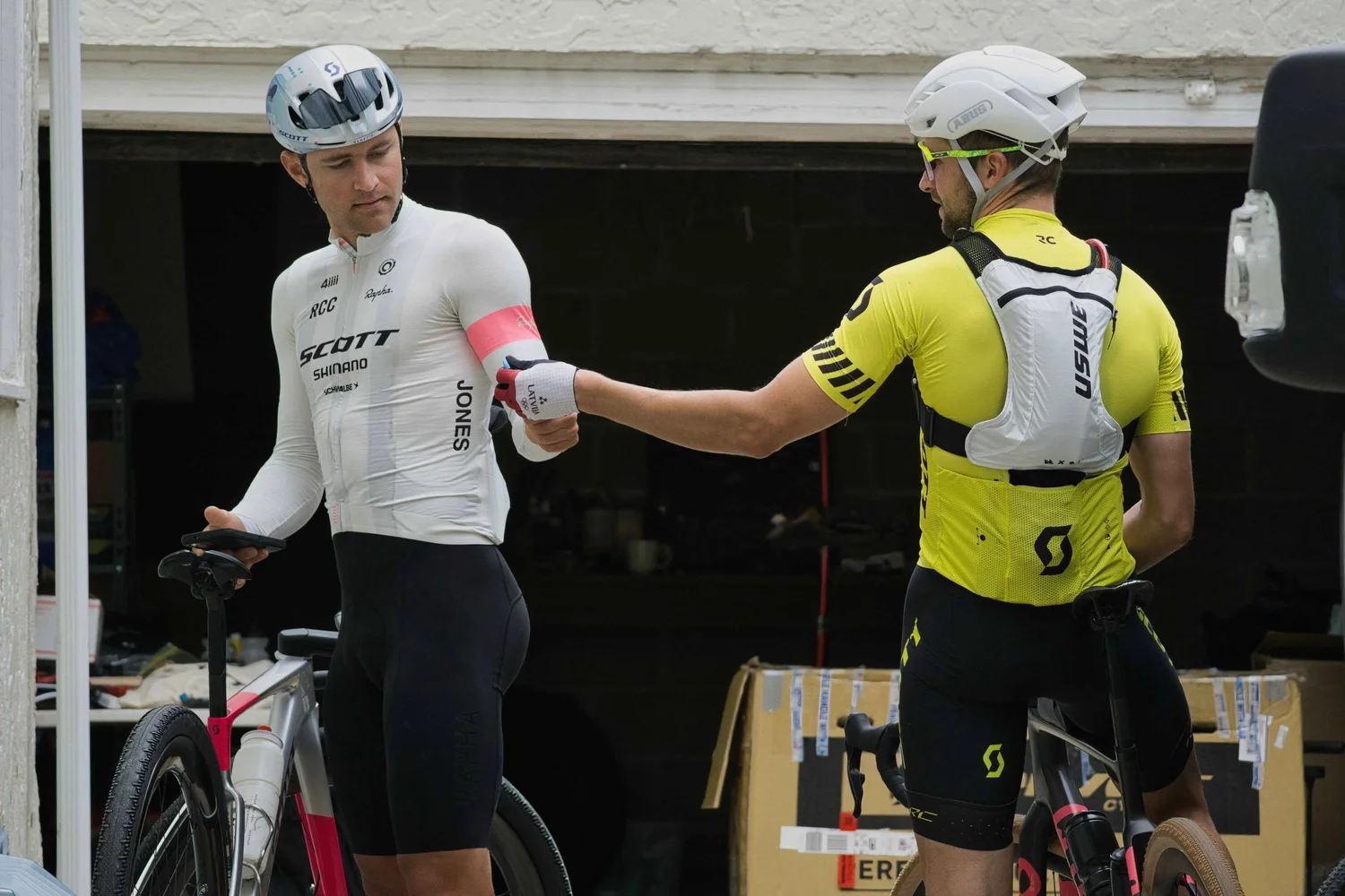 Coach handing a bottle to a rider during a gravel race in the USA