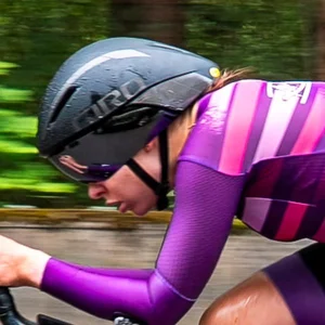 Krista Pūcīte racing a time trial in a purple kit