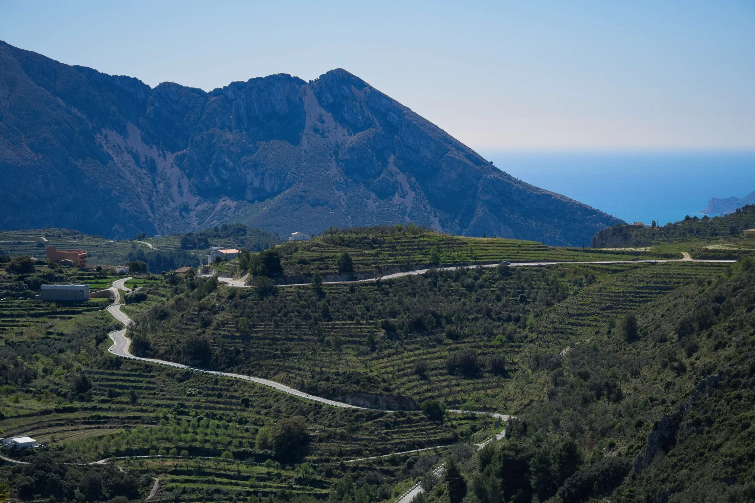 Winding roads through terraced hills of the Marina Alta, with Bèrnia and the Mediterranean behind