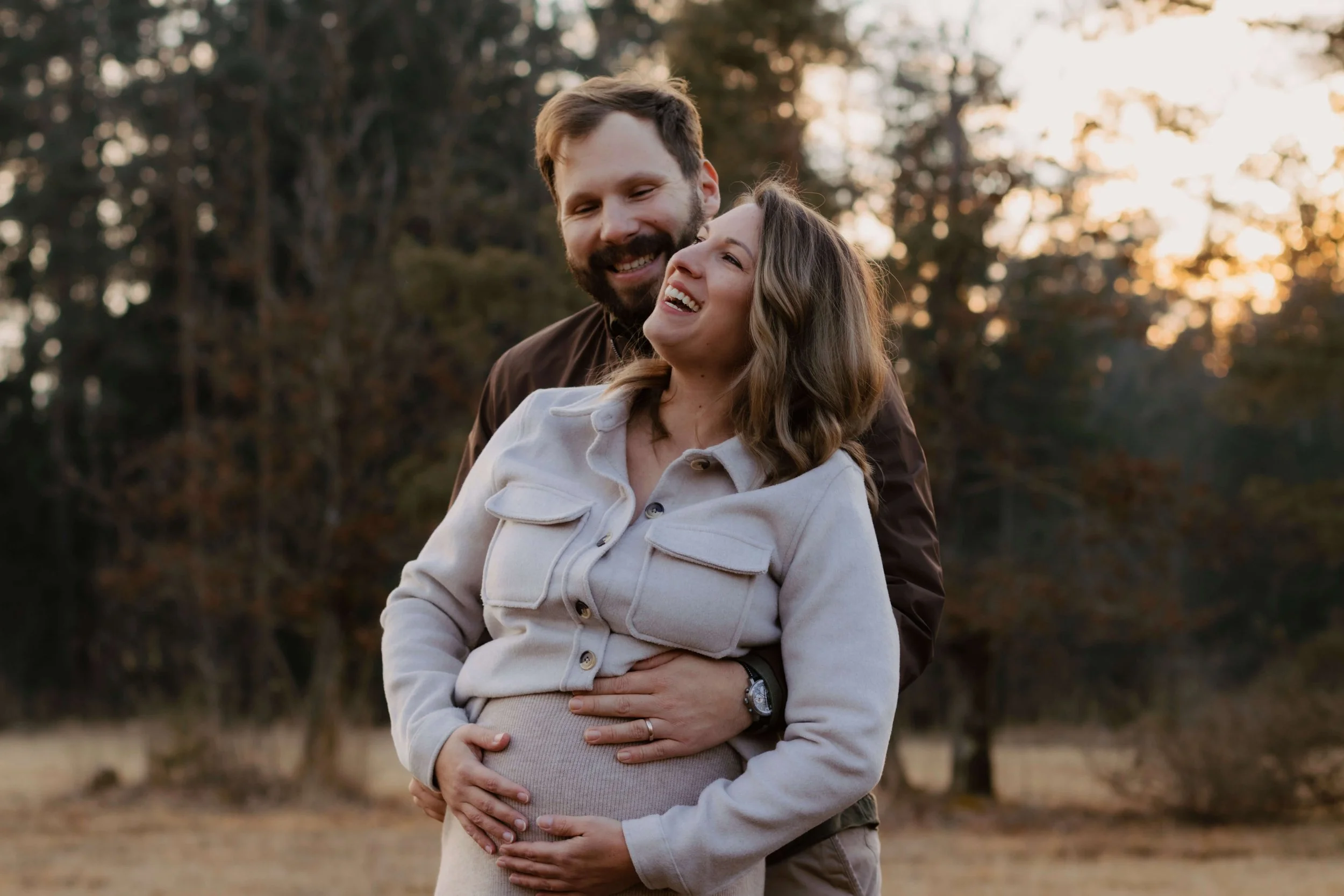 Babybauchshooting im Winter mit lachendem Paar in Bad Tölz – Schwangerschaftsfoto von Fotografin Vivian Bergmann