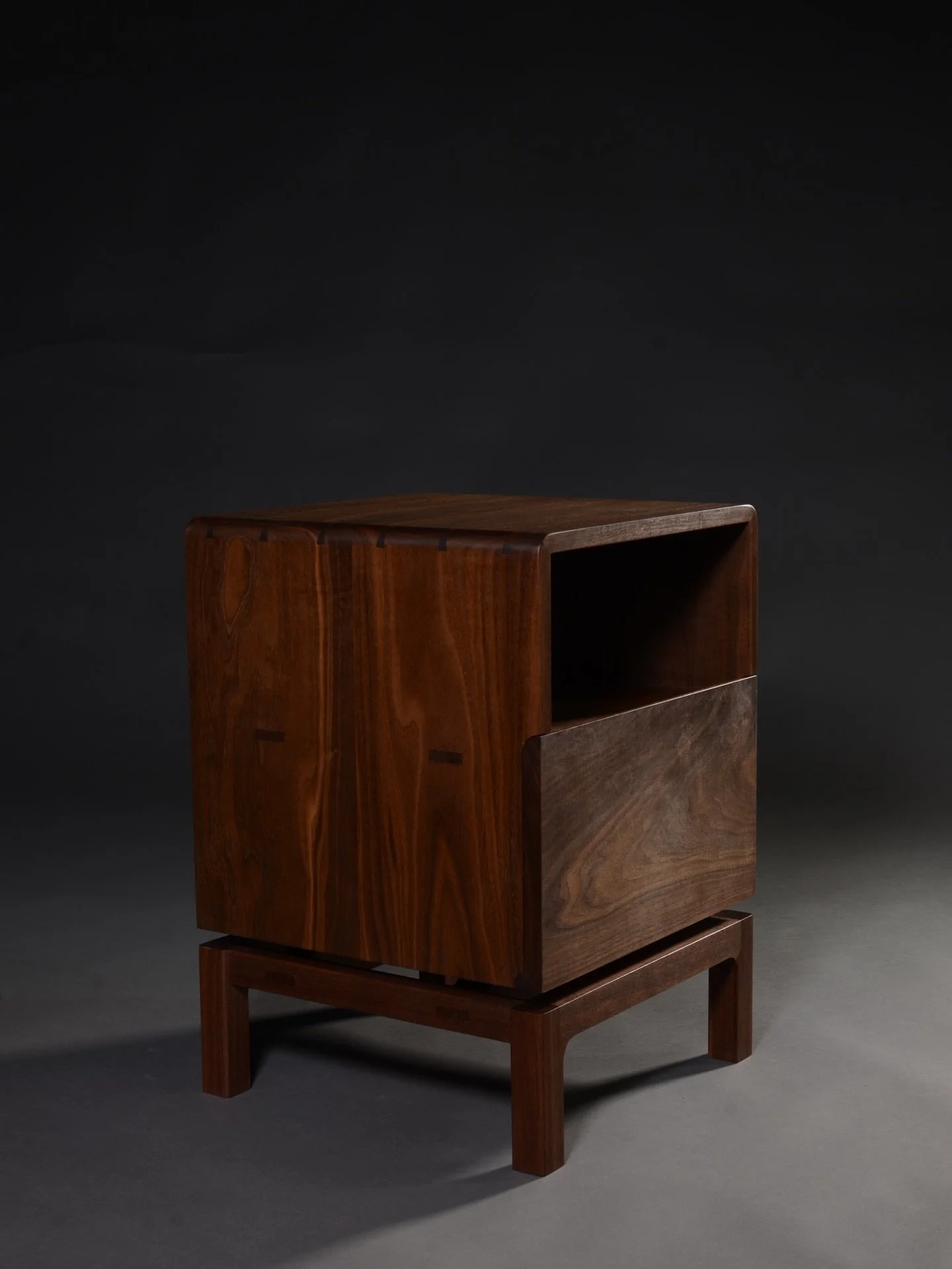 My first fully self-designed and self-built piece at Waters &amp; Acland. Solid walnut bedside table with maple accents. Dovetailed drawers concealed behind a drop-down door using a handmade wooden hinge. Four handcut tenons on each side provide stre
