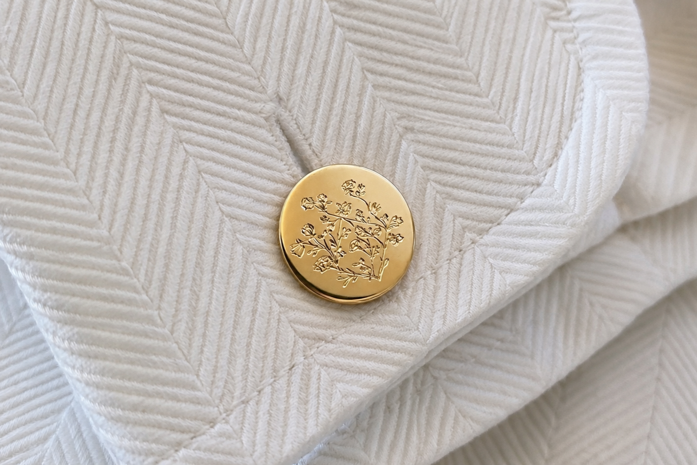 Un bouton de manchette en or gravé représentant un rosier