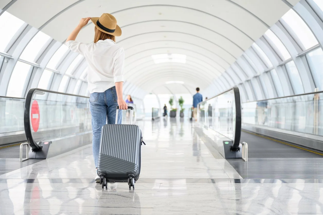 Filuent A woman with hand luggage walking in airport terminal