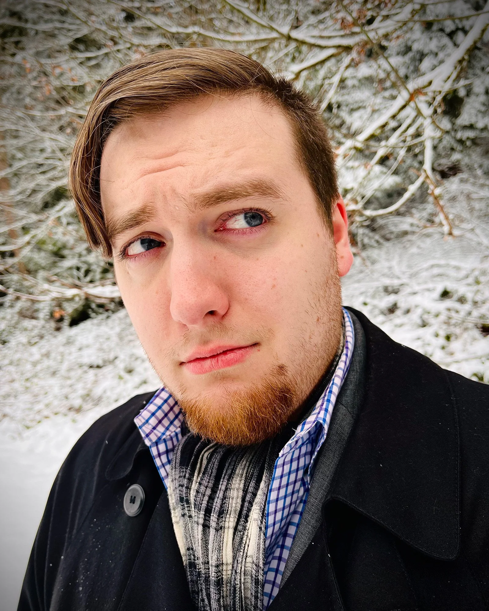 Nat Krieman, a light skinned man with short brunette hair swept to the side. He's facing the camera but looking to the side.