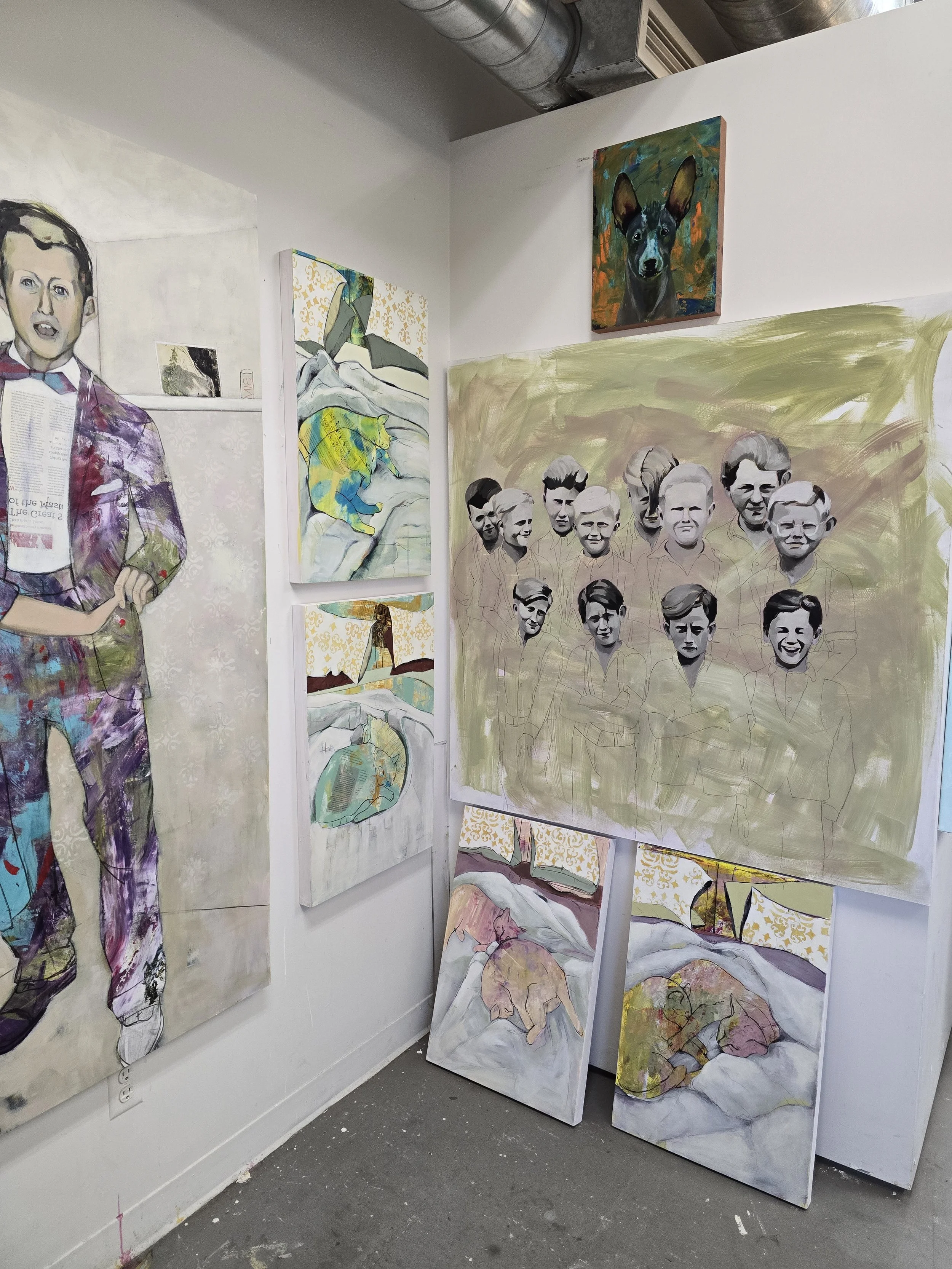 An art gallery corner displaying several paintings, including a large unfinished portrait of a group of people, a painting of a person sleeping, a colorful drawing of a sleeping dog, a small portrait of a dog, and a full body portrait of a person in 