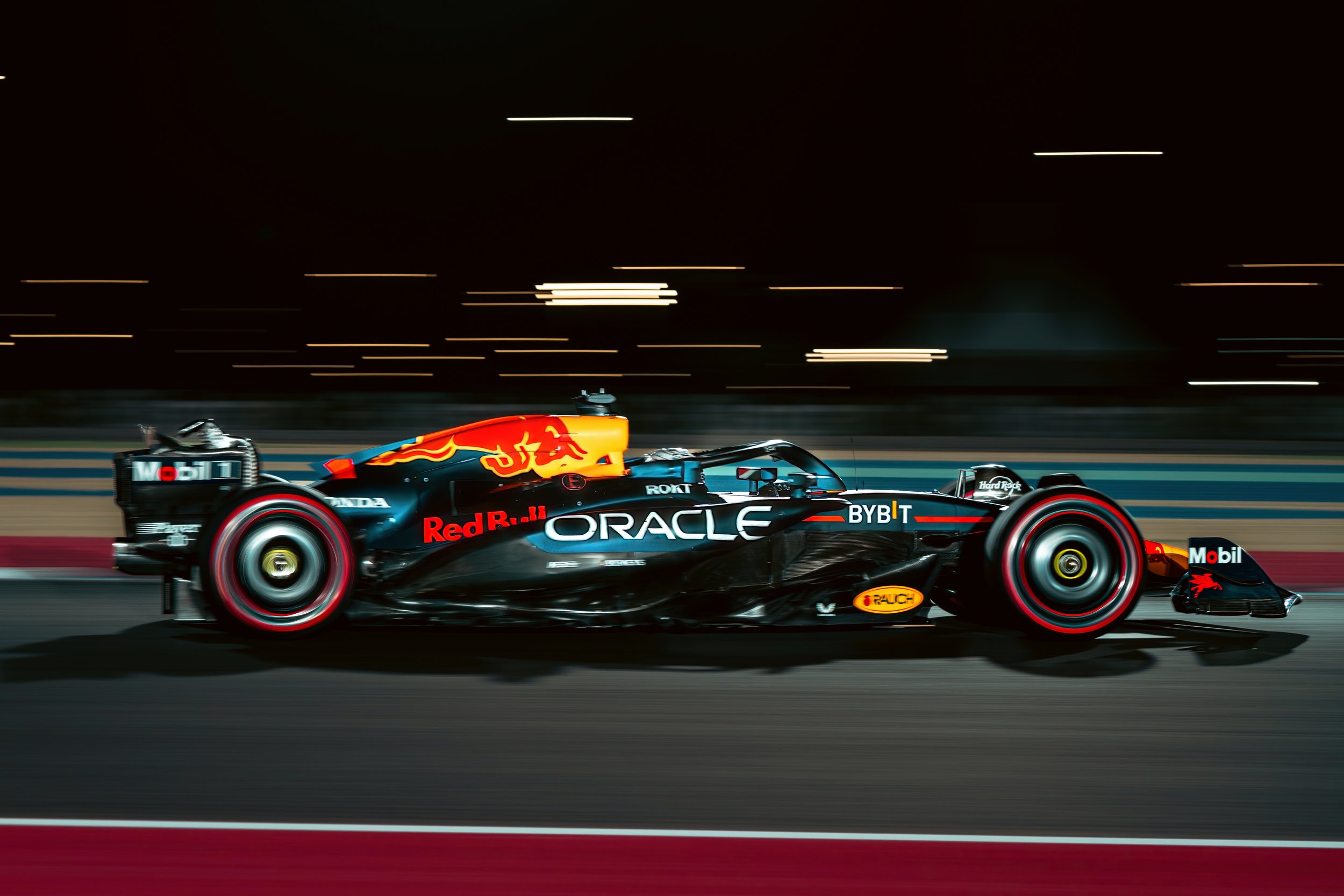Formula 1 race car speeding on track, featuring Oracle and Red Bull logos.