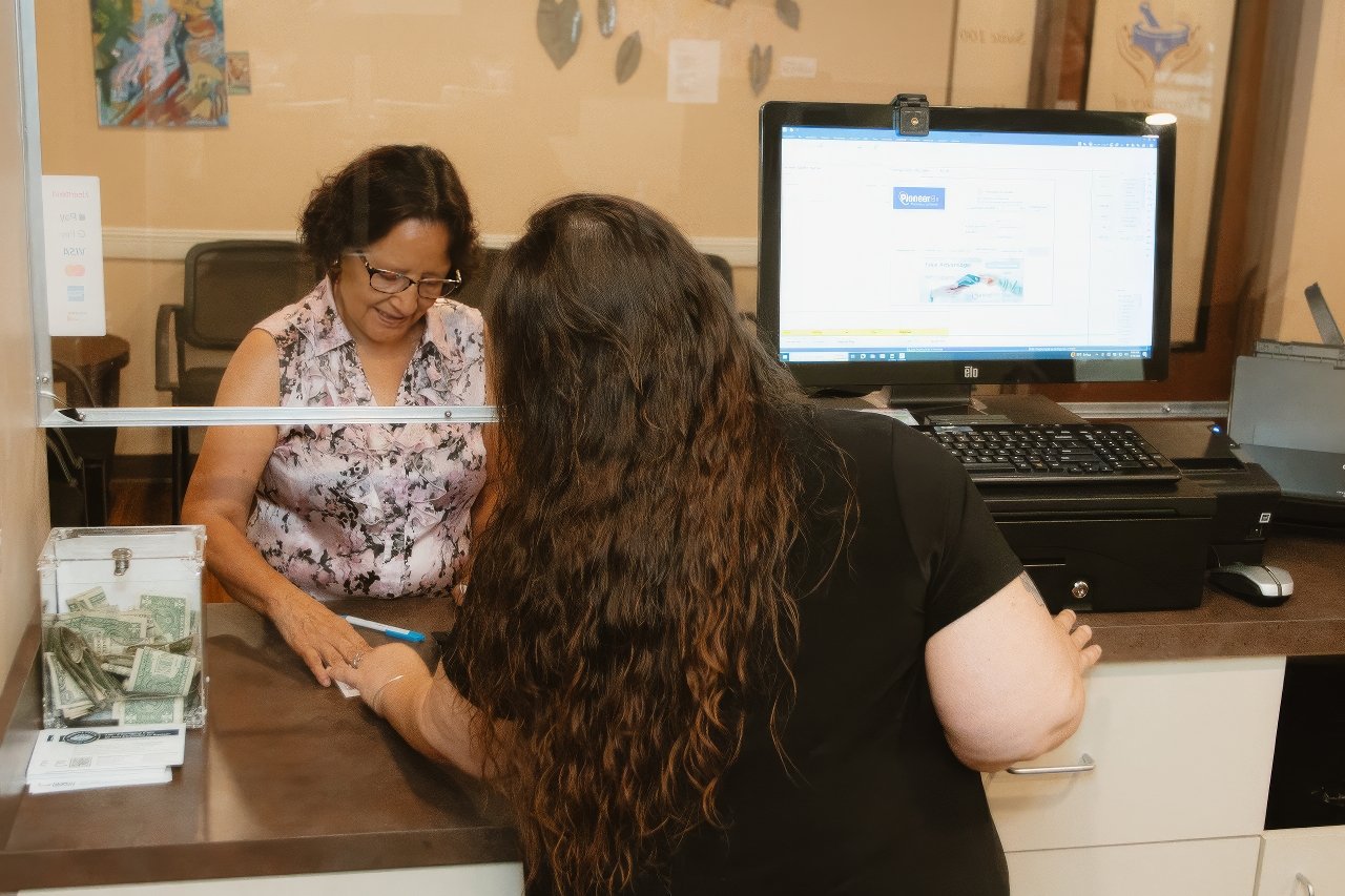 Staff updating patient prescription records to enhance Mercy & Truth’s continuity of care.