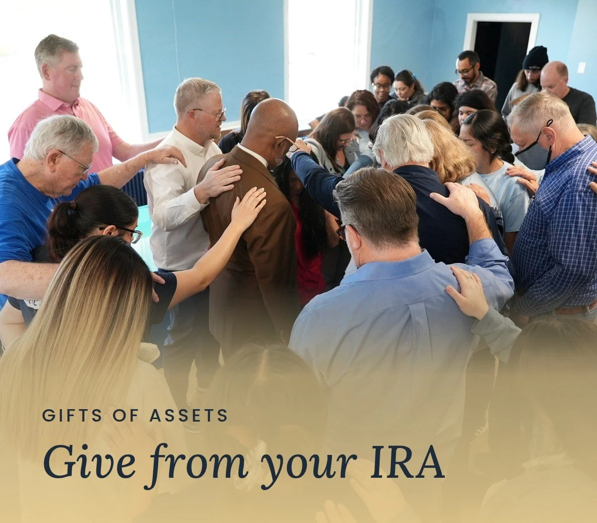 Members of the Mercy & Truth community gather with hands on one another's shoulders in prayer. Text reads "Gifts of Assets: Give from your IRA."